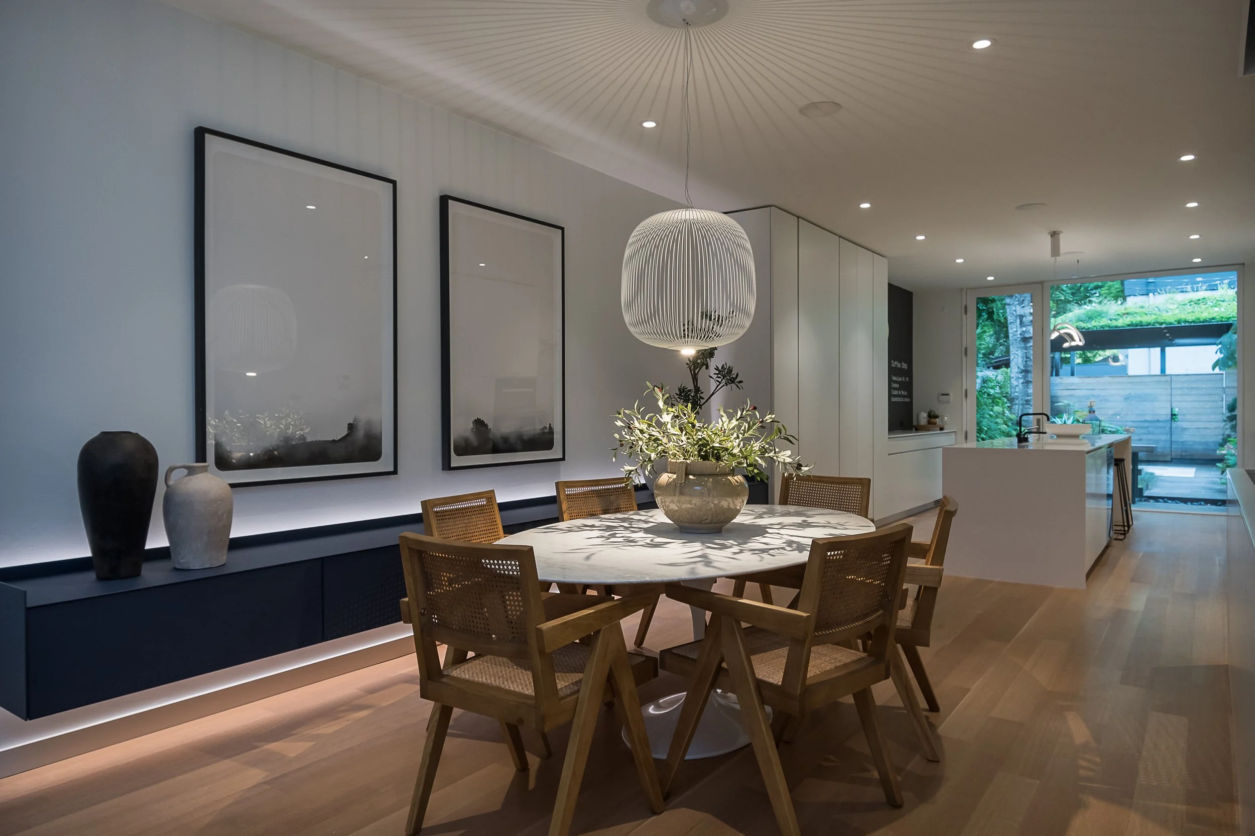 Dining room with marble oval table and floating millwork interior design in Toronto Ontario by JT & Co Interiors