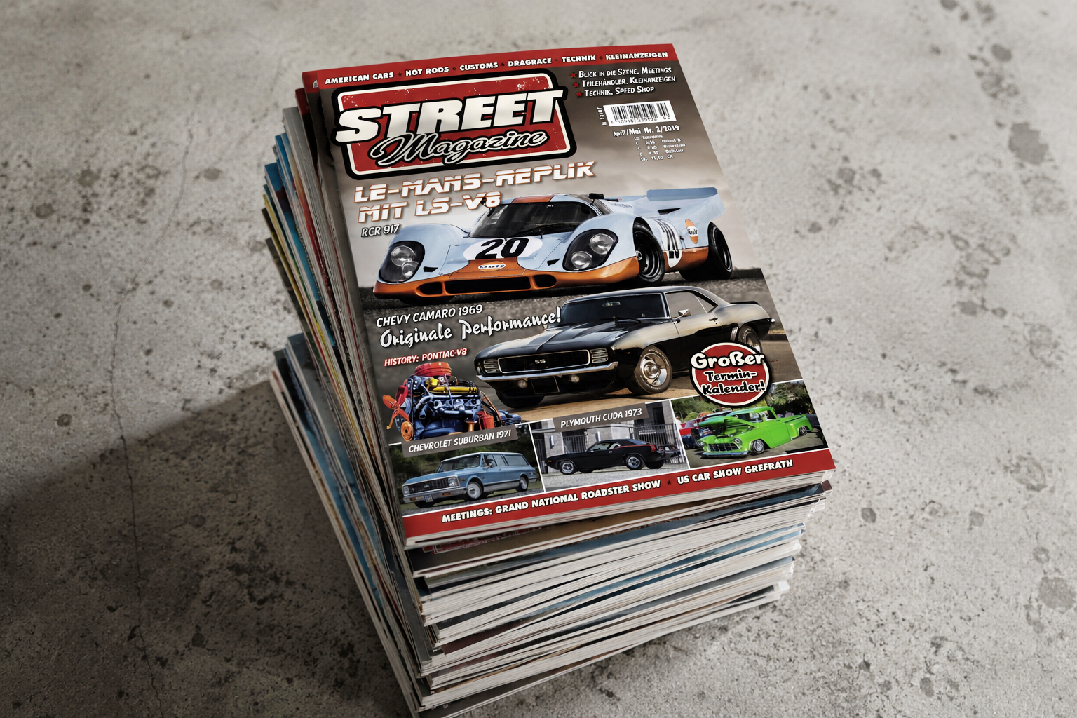 Stapel von Automobilzeitschriften mit einem Cover, das einen Le-Mans-Rennwagen, einen Chevrolet Camaro und weitere klassische Autos zeigt.