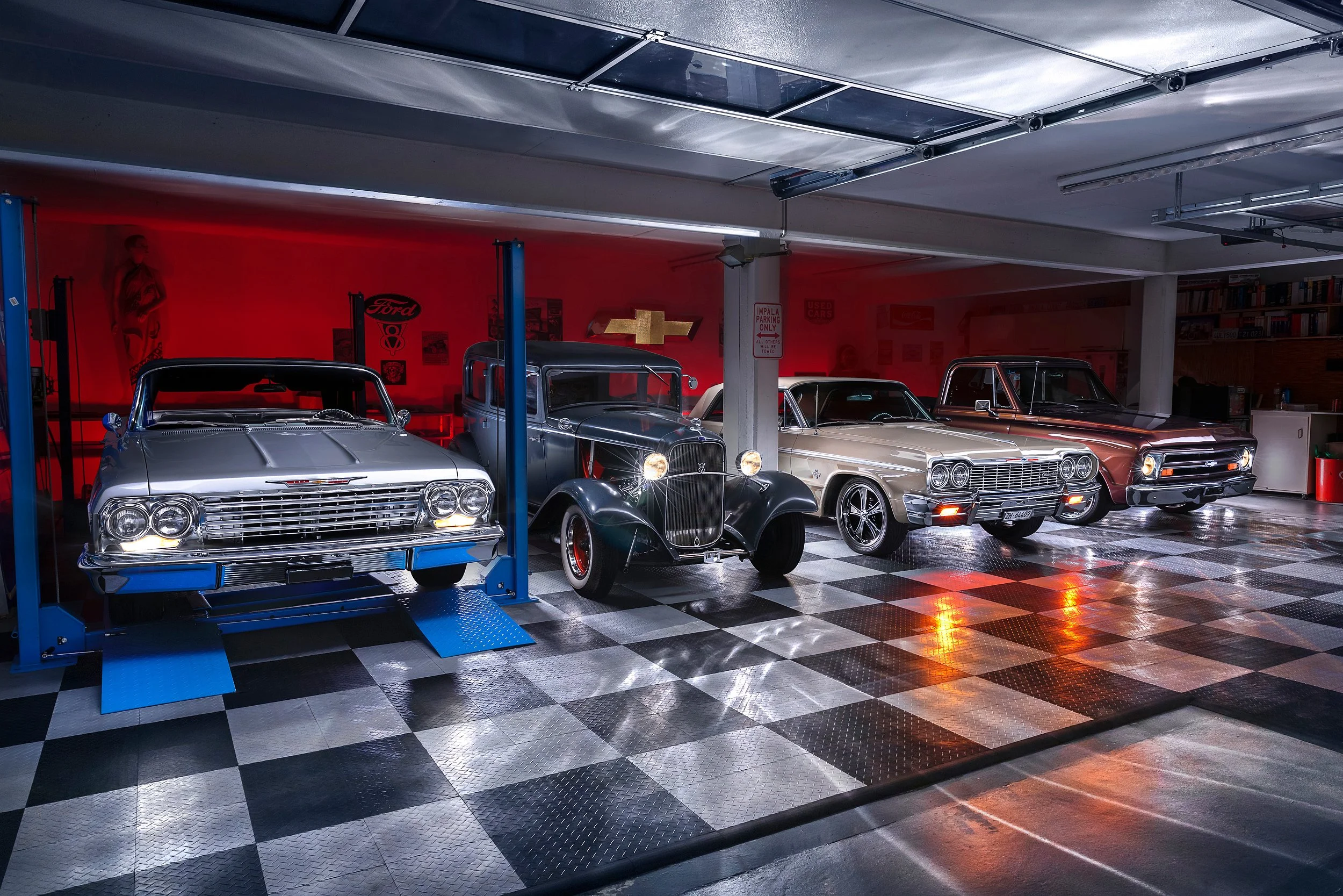 Ein Autolagerraum mit klassischen Autos, einem Autolift und rot beleuchteter Wand