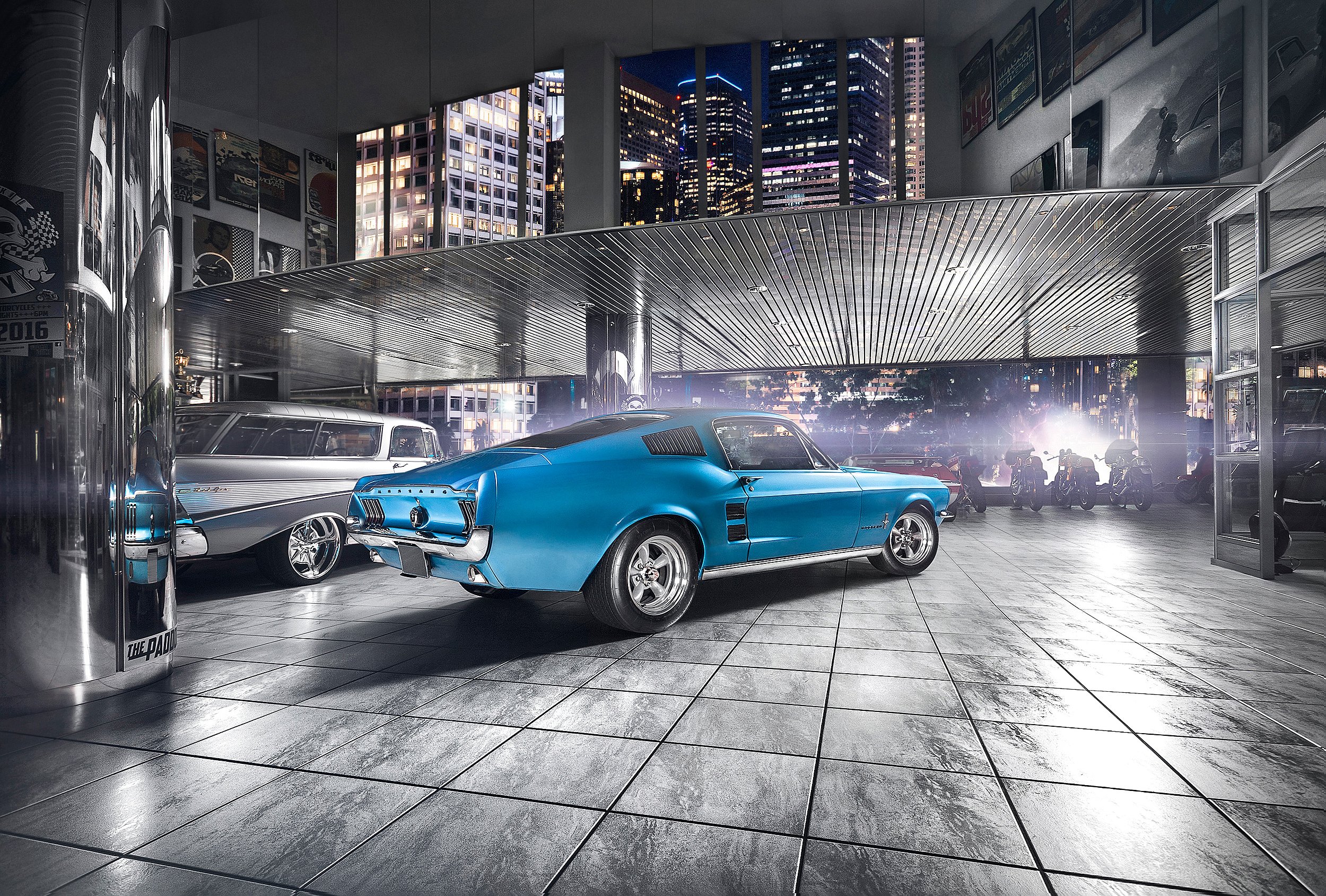 Blaue klassische Autos im Innenraum eines modernen Gebäudes bei Nacht mit hohen Gebäuden durch große Fenster im Hintergrund.