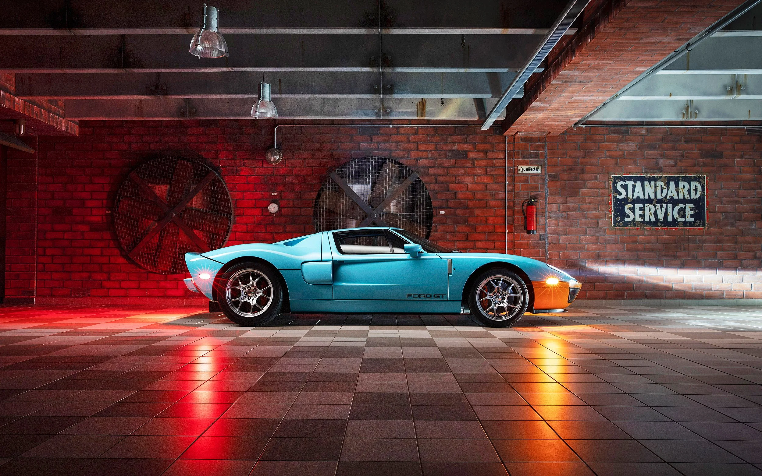 Blauer Ford GT Supersportwagen in einer modernen Garage mit roter Beleuchtung, rotem bricks Wand, großen Lüftern und einem Schild mit der Aufschrift "Standard Service".