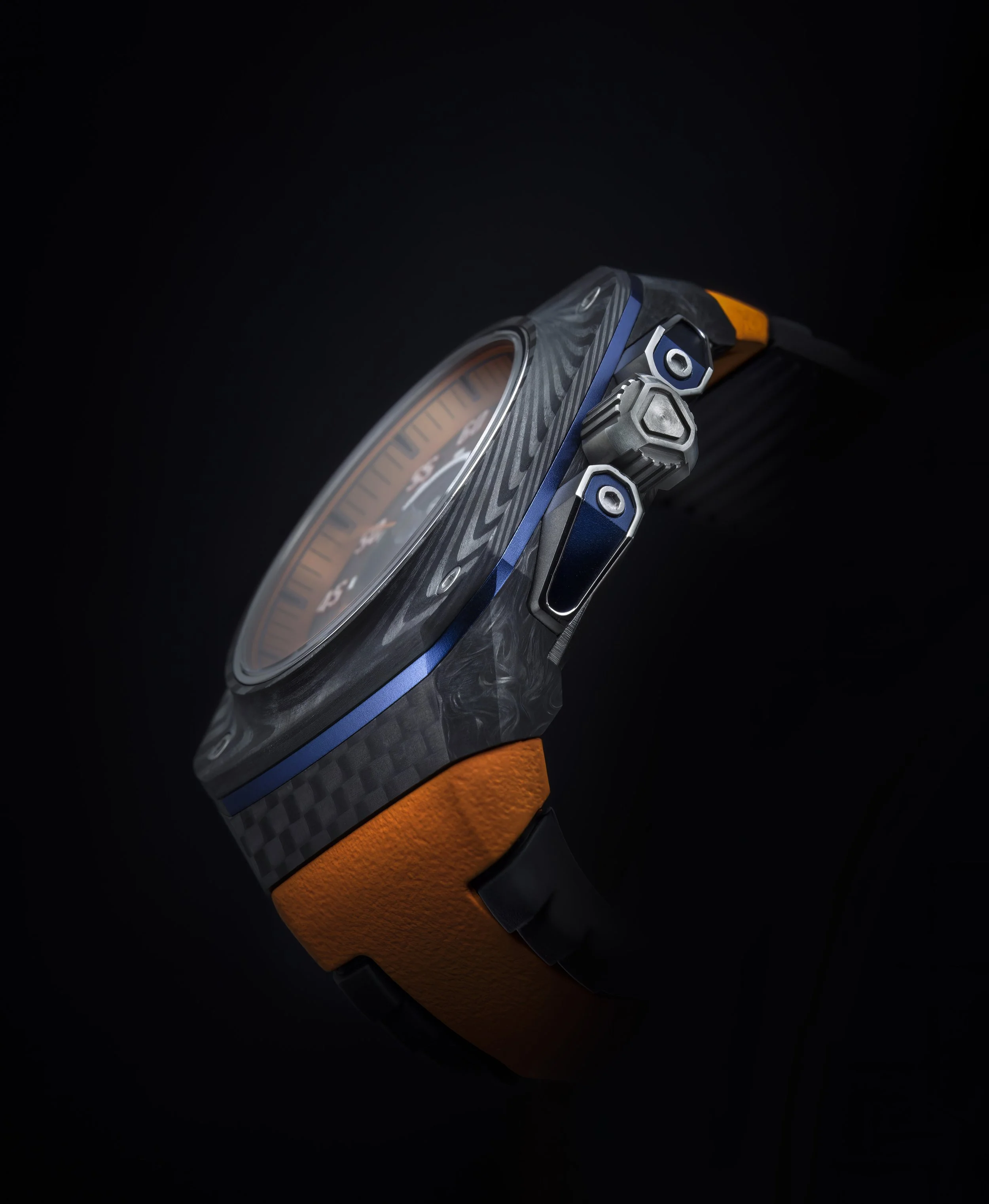 Nahaufnahme eines modernen Armbands mit buntem Zifferblatt, blauen und grauen Elementen, sowie einem orangefarbenen Band auf schwarzem Hintergrund.