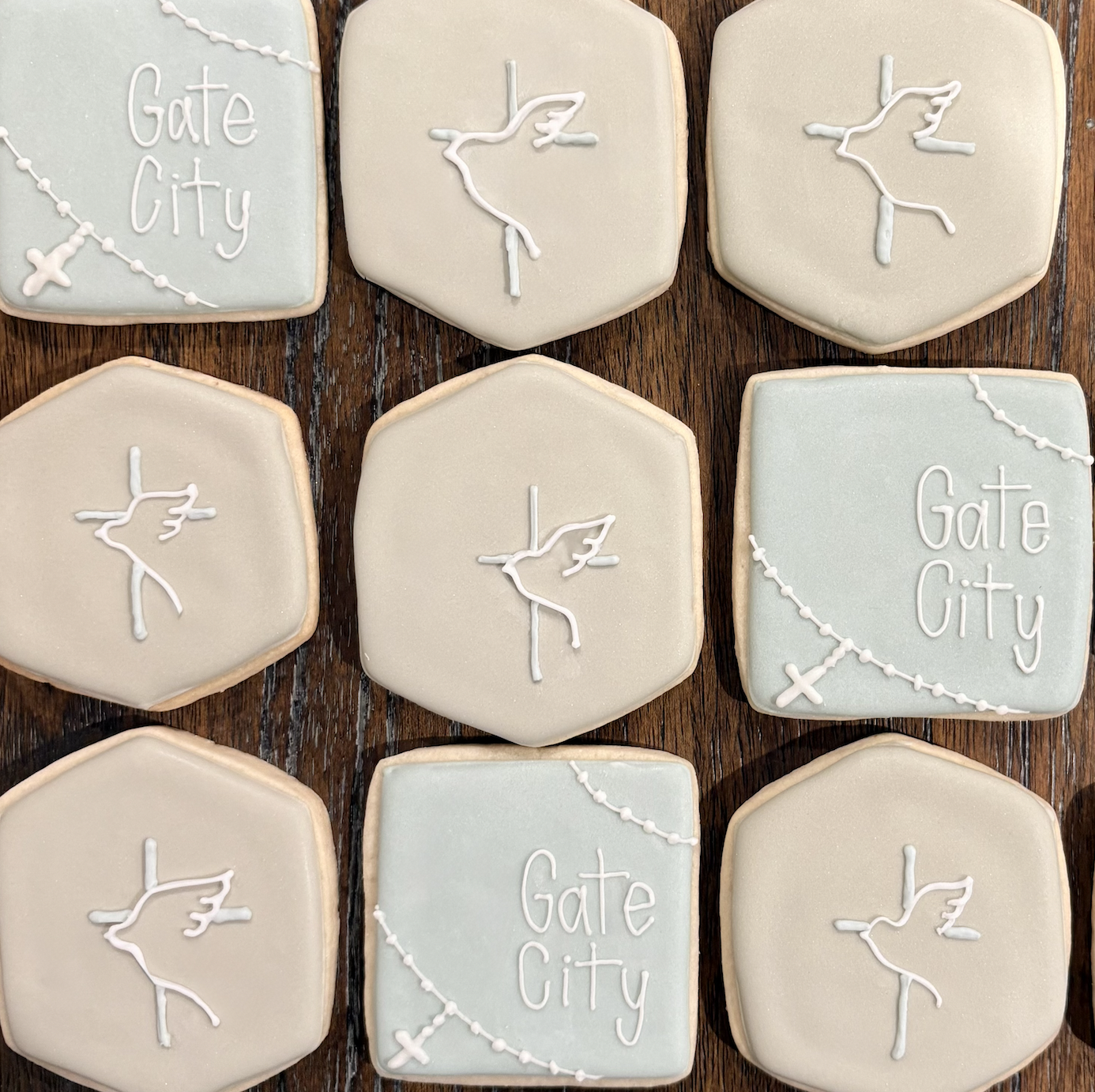 Decorative cookies with airplane, tree, and phrase "Gate City" designs, arranged on a wooden surface.