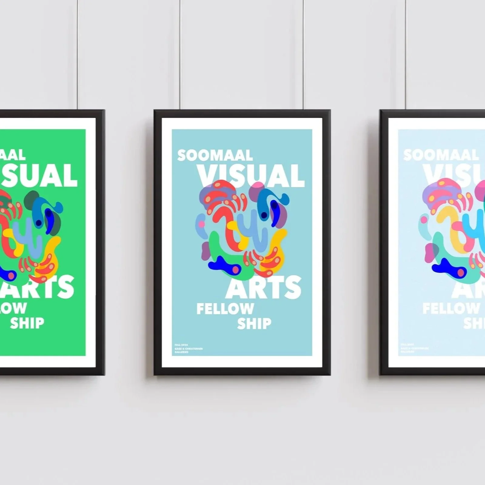 Three framed posters advertising an art exhibition titled 'SooAal Visual Arts Fellowship'. The posters feature colorful abstract designs and are hung side by side on a white wall.