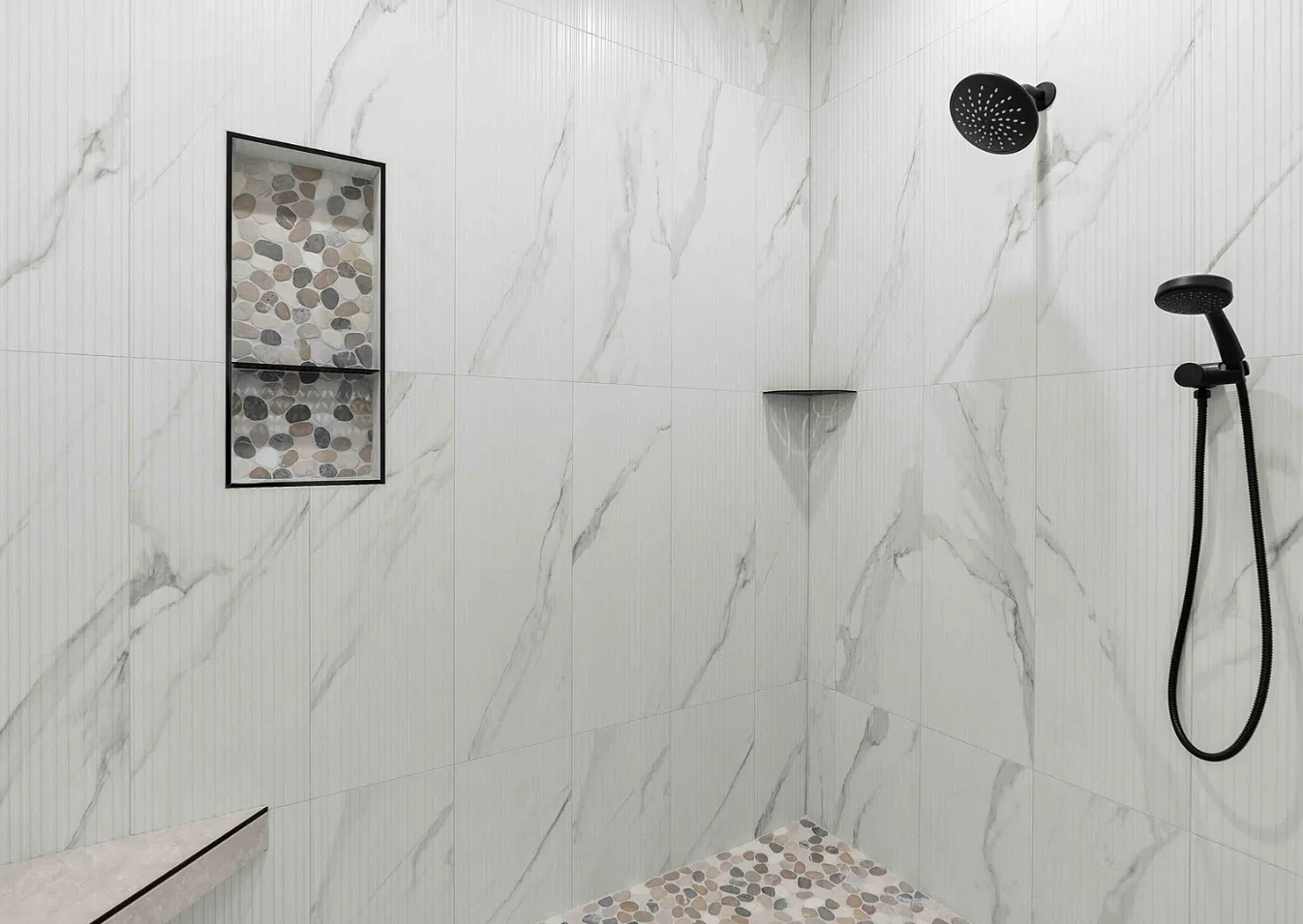 Shower with white marble tiles, a black handheld showerhead with hose, a black rain showerhead, a niche with pebble tiles, a small corner shelf, and a pinkish stone bench.