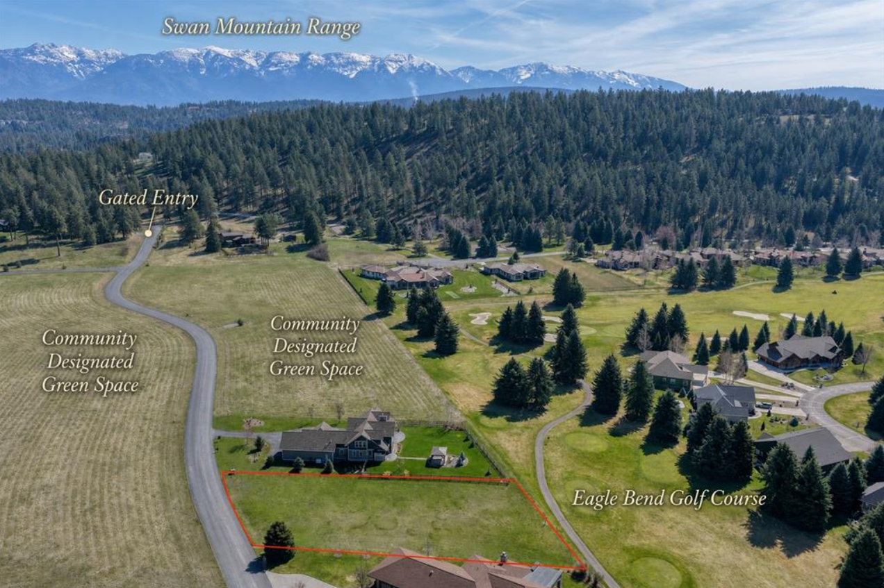 Aerial view of a community with green spaces, houses, and a golf course with snow-capped mountains in the background, featuring labels for Swan Mountain Range, Gated Entry, Community Designated Green Space, and Eagle Bend Golf Course.