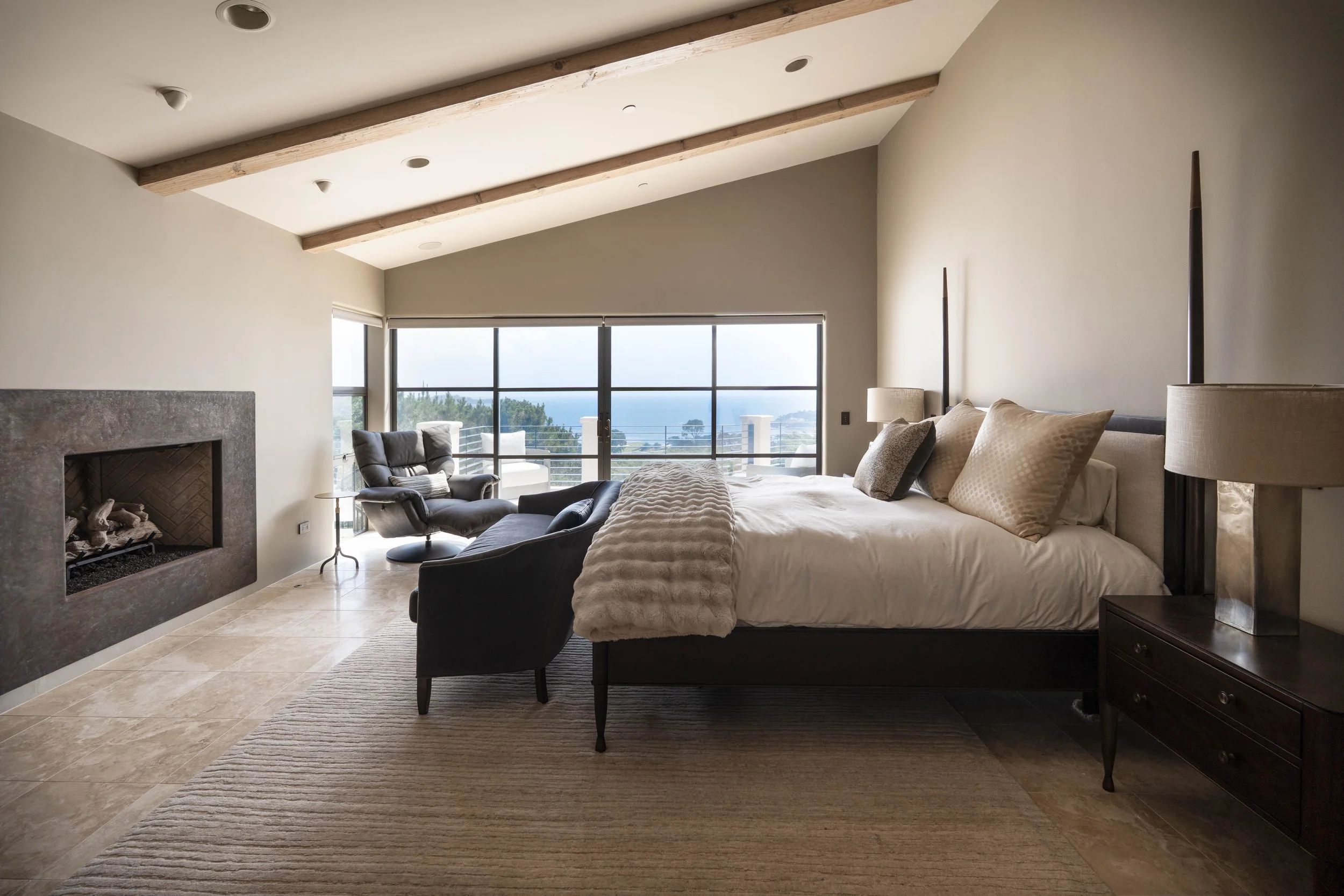 Master suite with king bed, fireplace, and ocean views.
