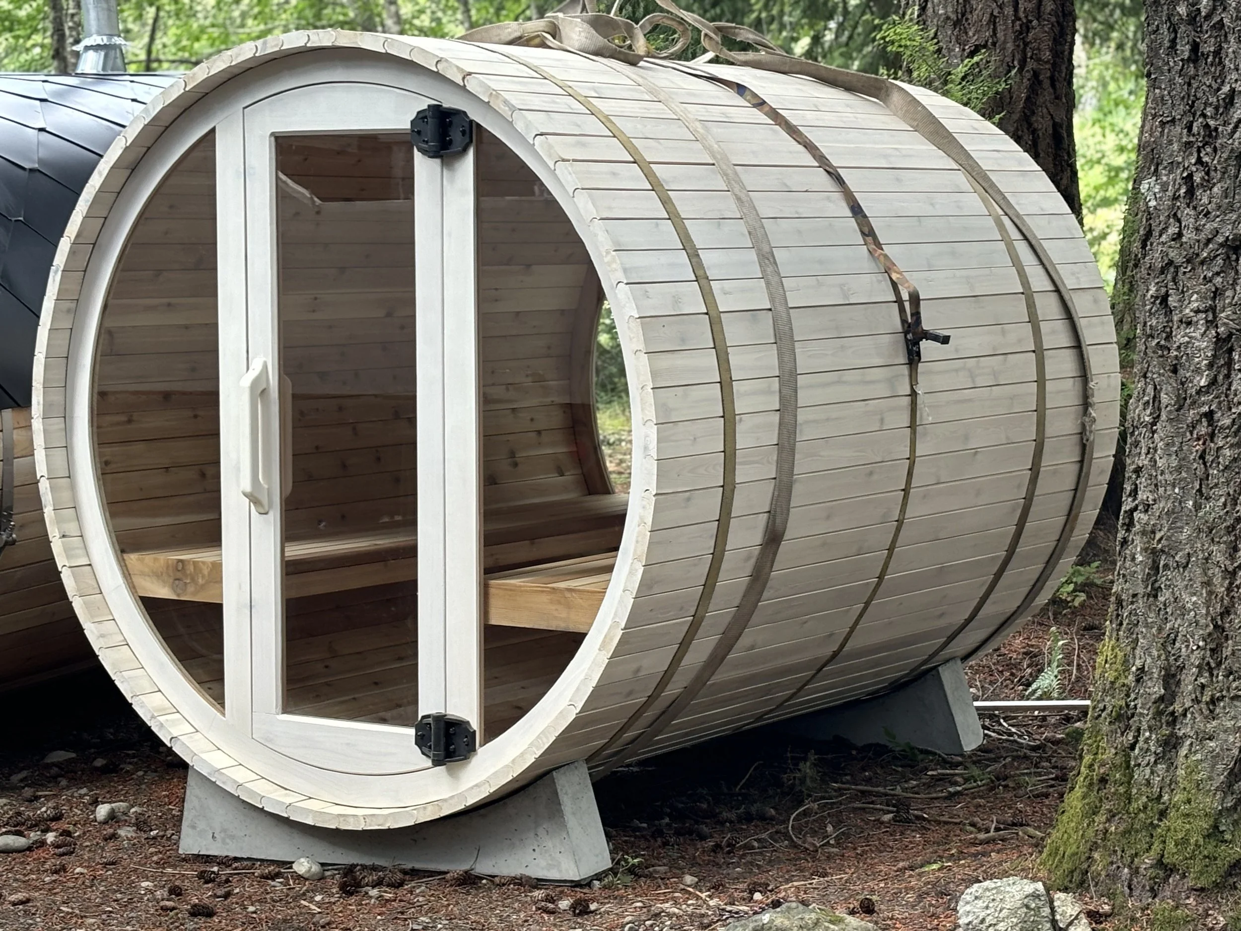 Cedar barrel sauna with a bright whitewashed finish and full glass door.