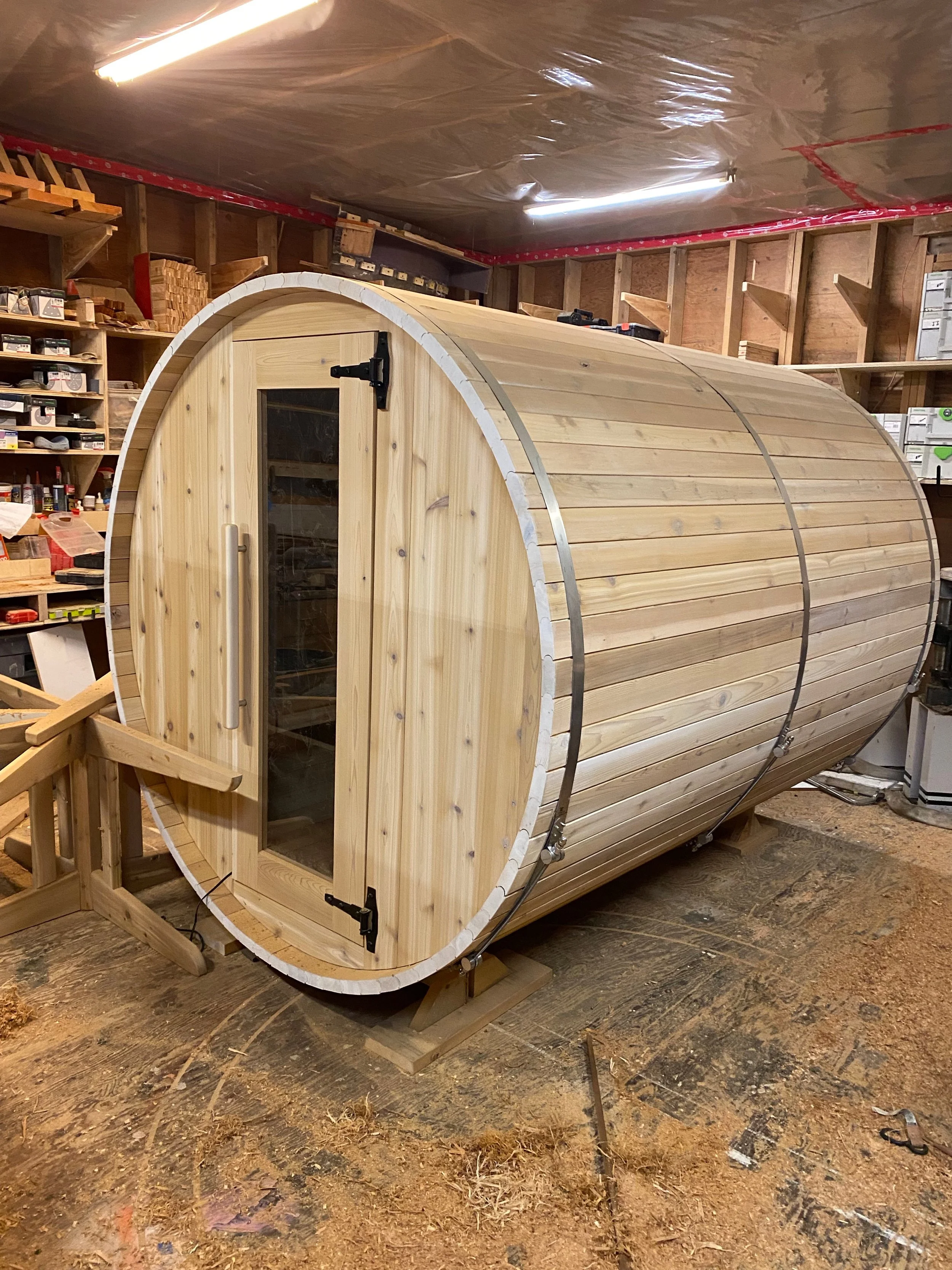 Classic cedar barrel sauna with a natural finish and glass door.