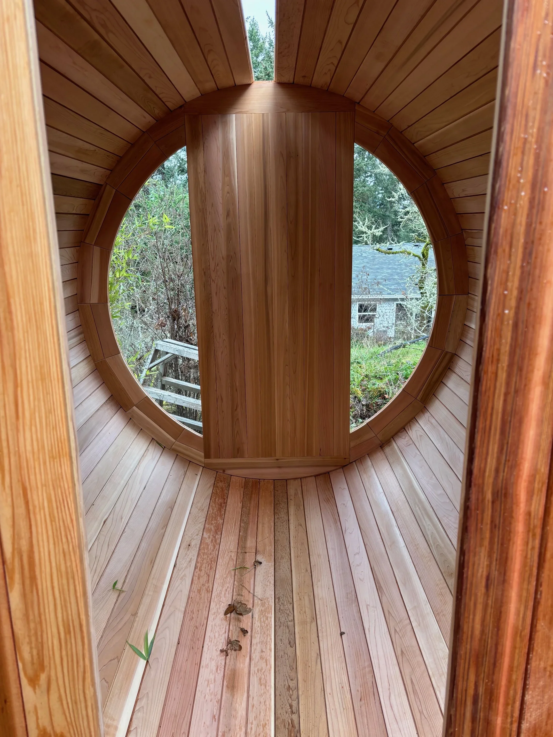 Bright cedar sauna interior with a full rear window and clean, open design.