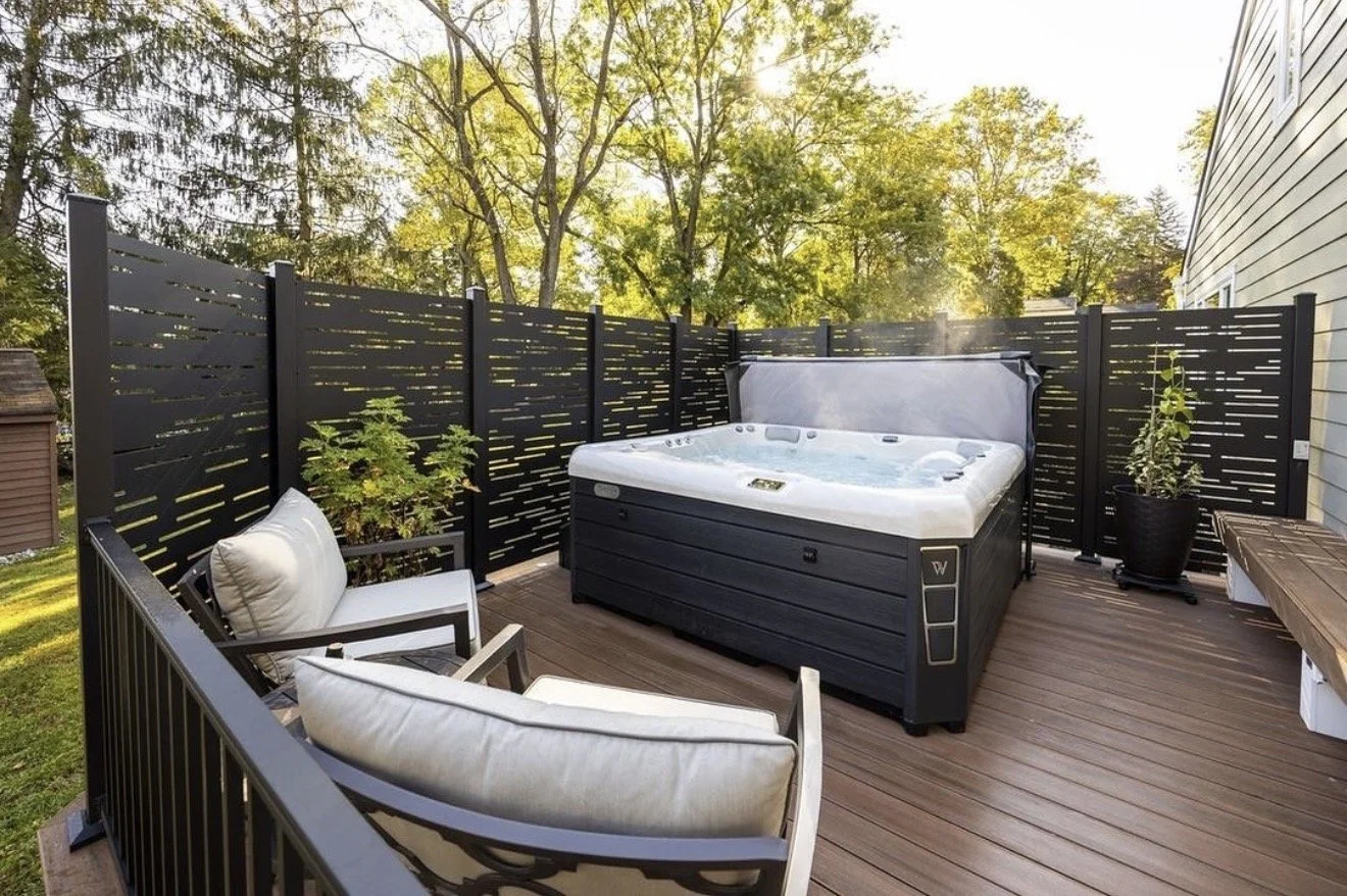 composite deck with decorative privacy screens surrounding hot tub