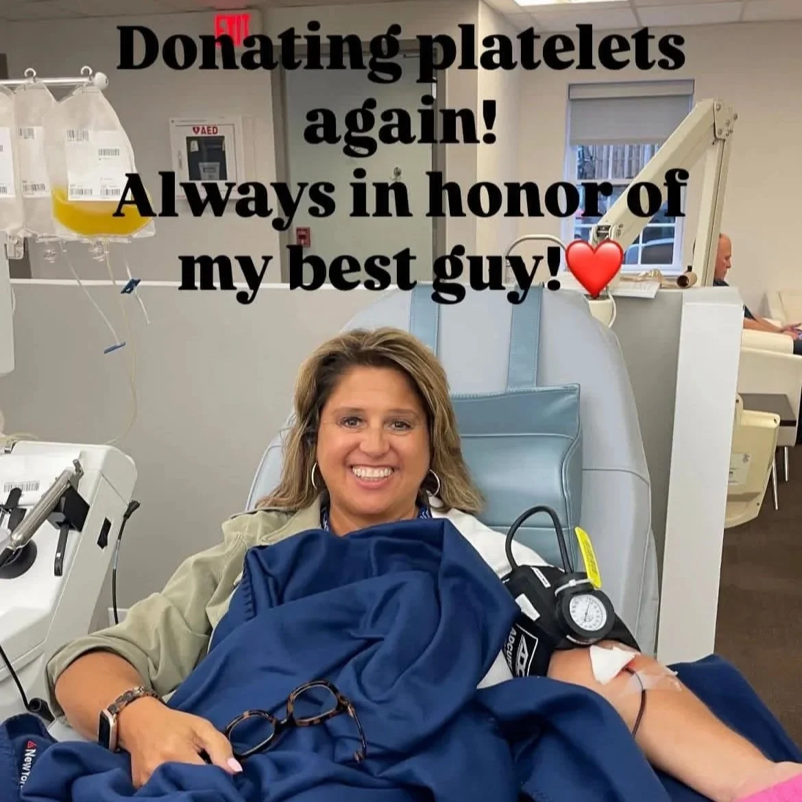 A woman smiling while donating blood at a medical facility, with a blood bag hanging nearby. The photograph has text overlaid that reads, 'Donating platelet again! Always in honor of my best guy!' with a red heart emoji.