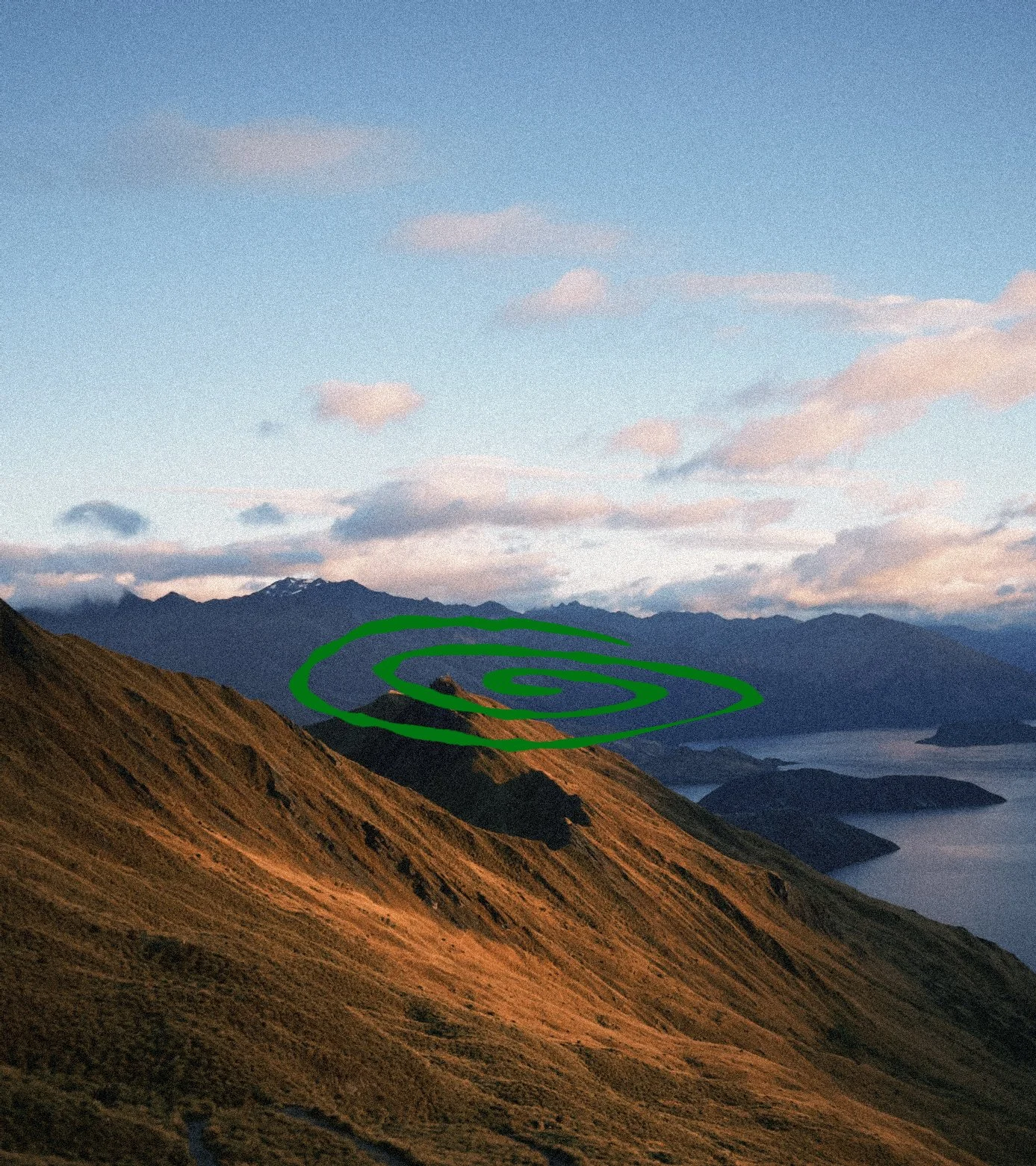 Scenic landscape of rolling hills with mountains in the background under a partly cloudy sky, marked with green spiral lines.