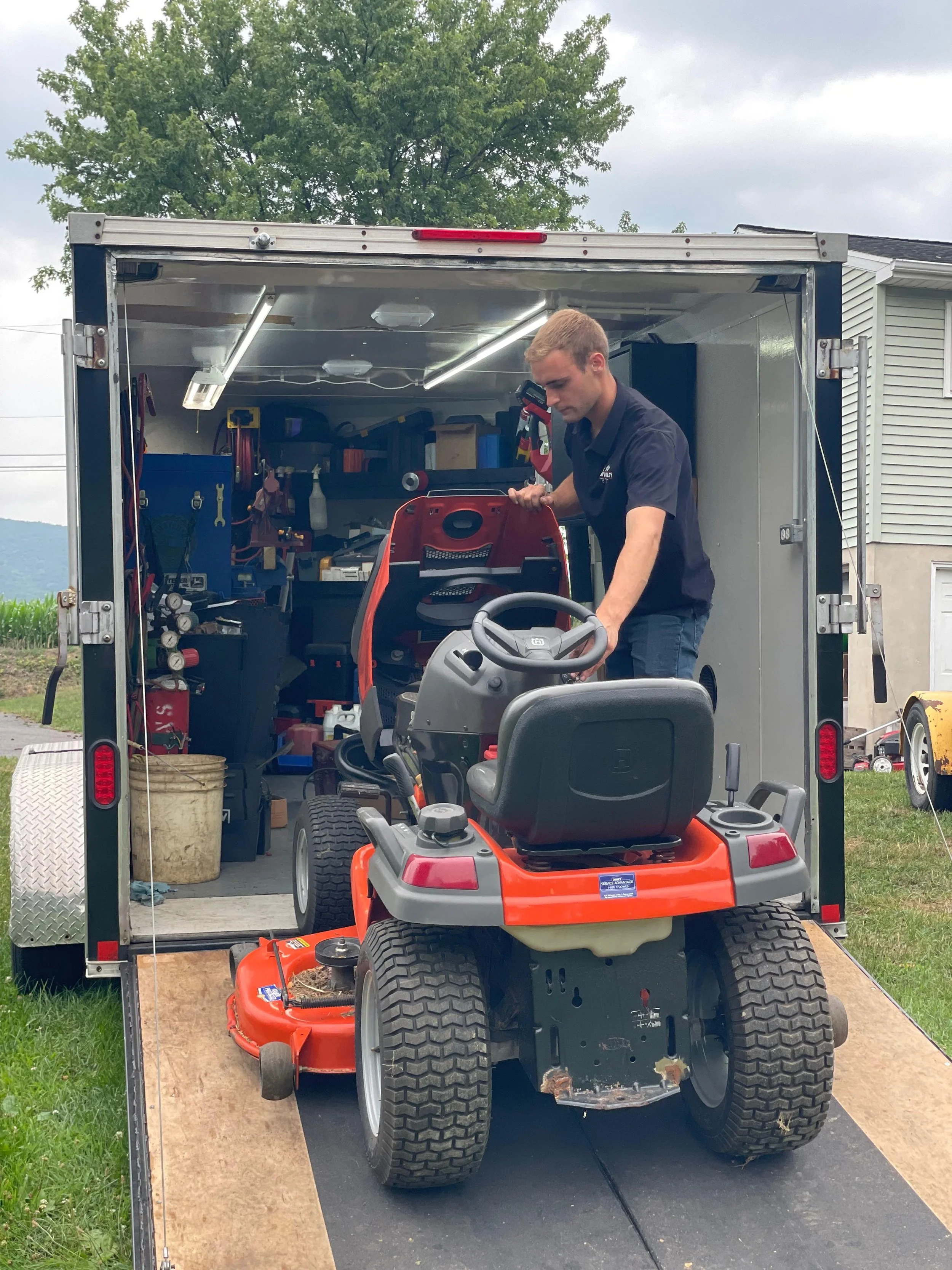 Iron Valley Small Engines Technician working on lawn mower