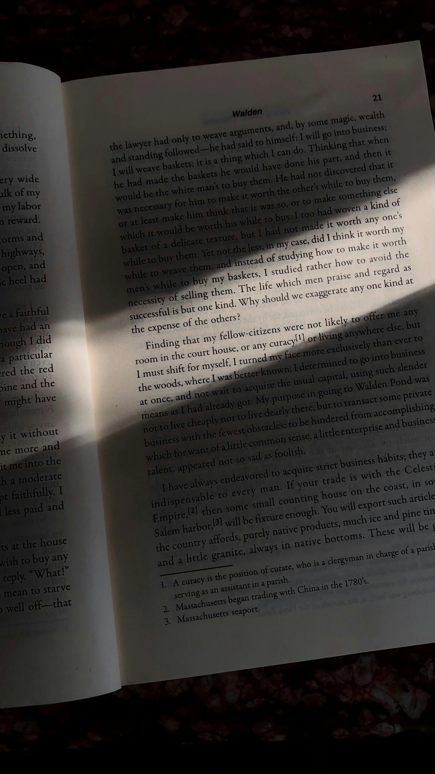 Open book showing a page with text about weaving baskets, studying Chinese trade, and the meaning of a curacy; the photo is partially shadowed.