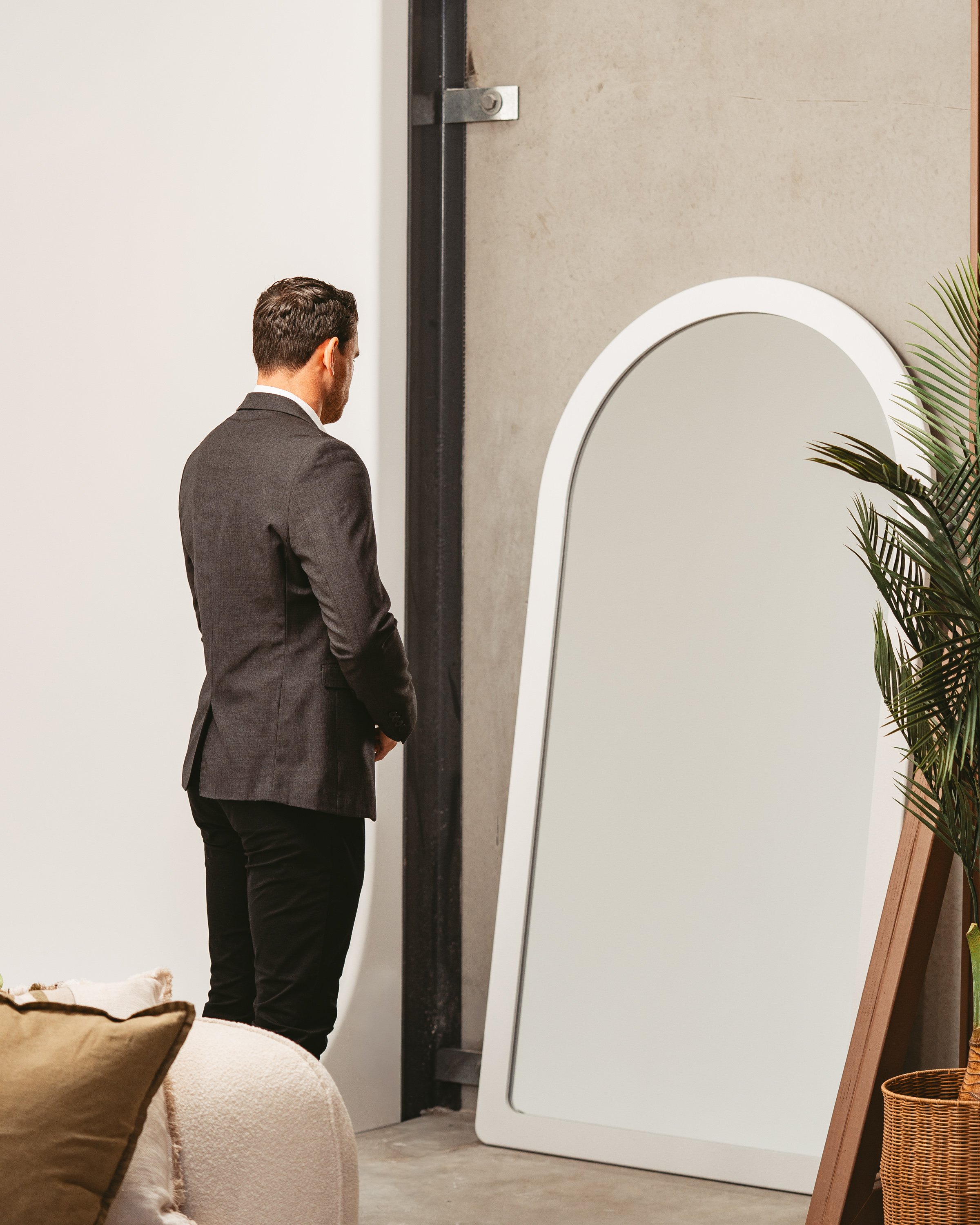 Man standing in front of a white arched mirror