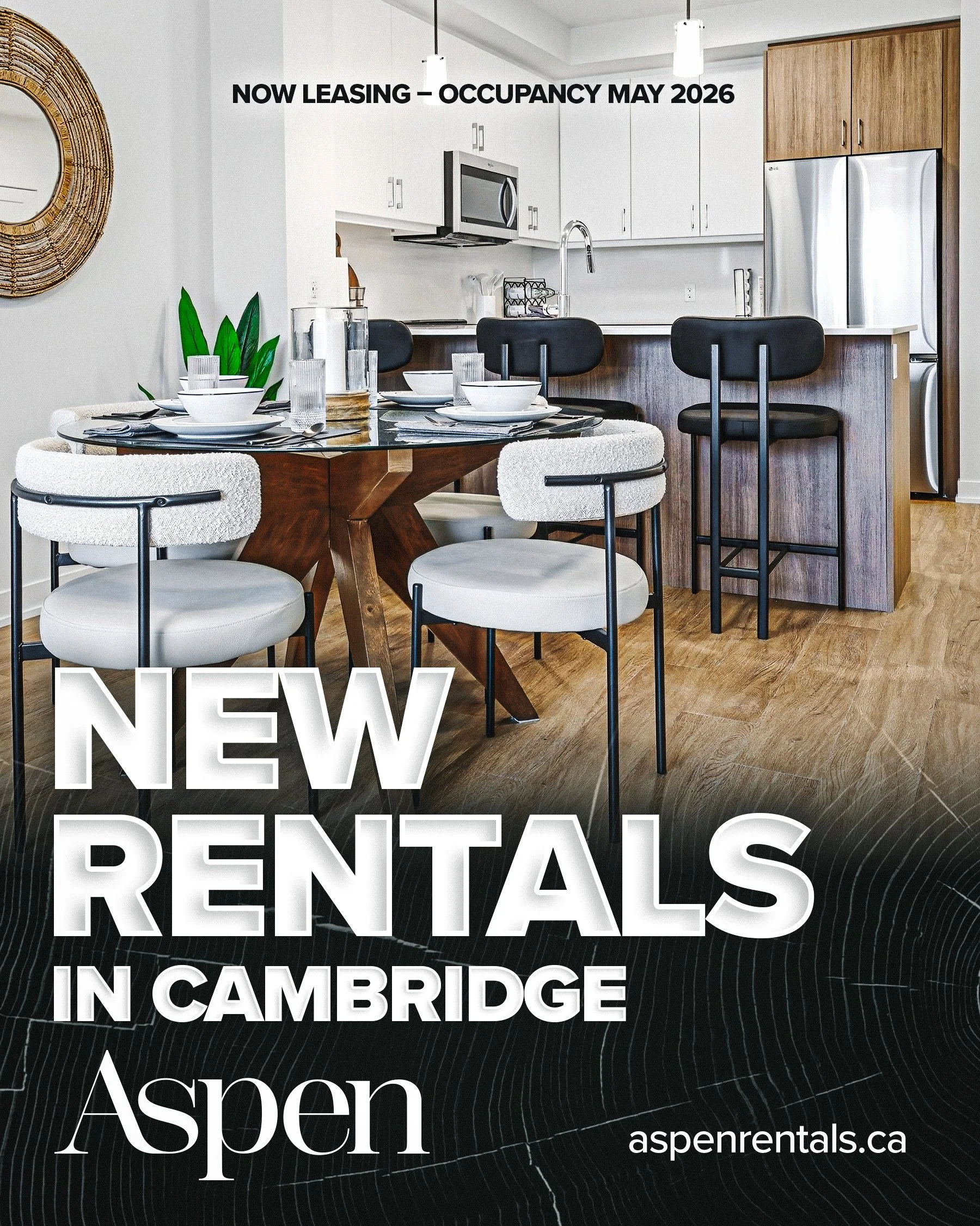 Interior of a modern apartment with a dining area and kitchen, featuring a round wooden dining table with white chairs, a kitchen counter with black barstools, and appliances like a refrigerator and microwave. The image promotes new rental listings i