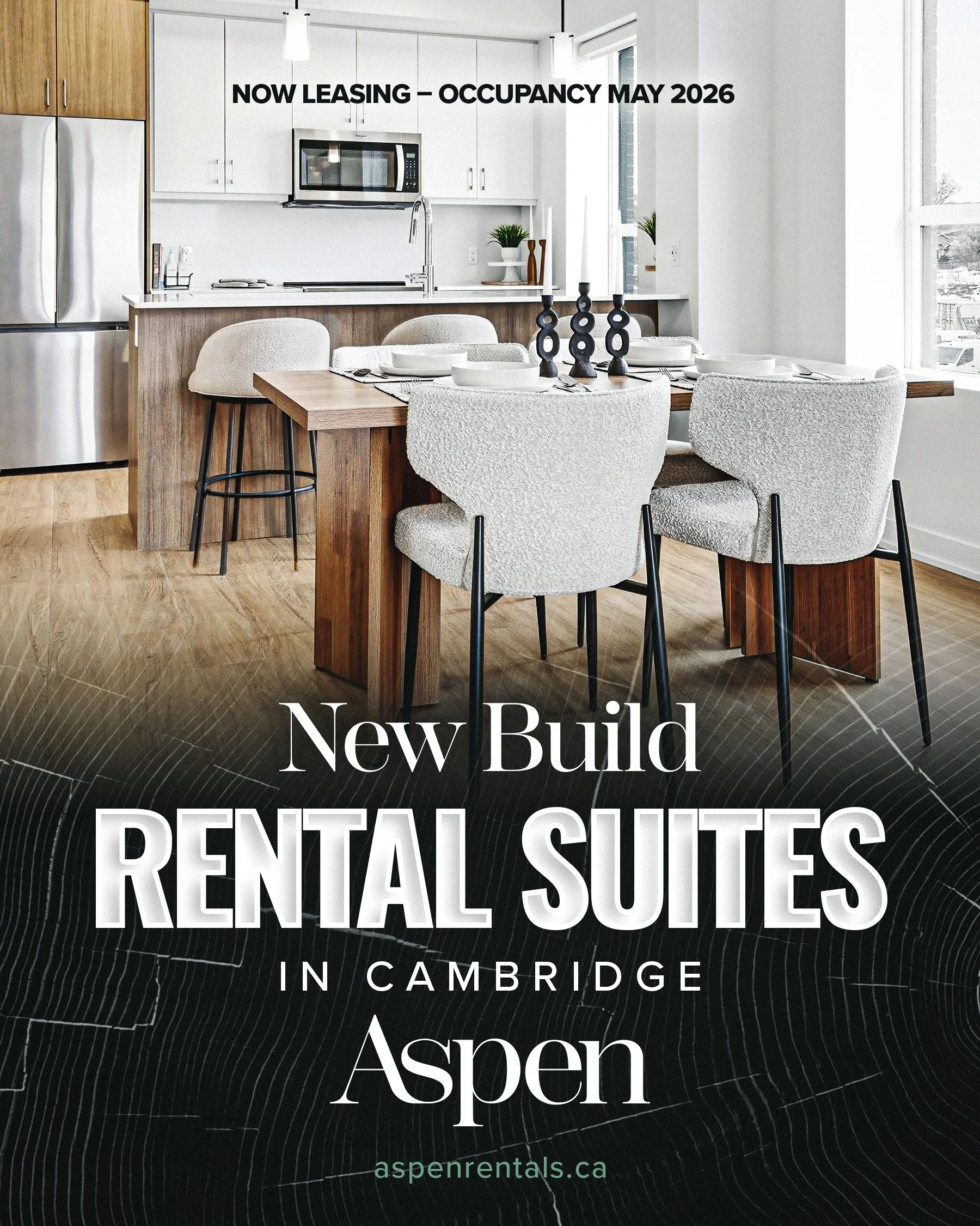 Interior of a modern kitchen and dining area with white cabinets, a microwave, a stainless steel refrigerator, and a wooden dining table with six chairs, set for a meal, with candles and tableware.
