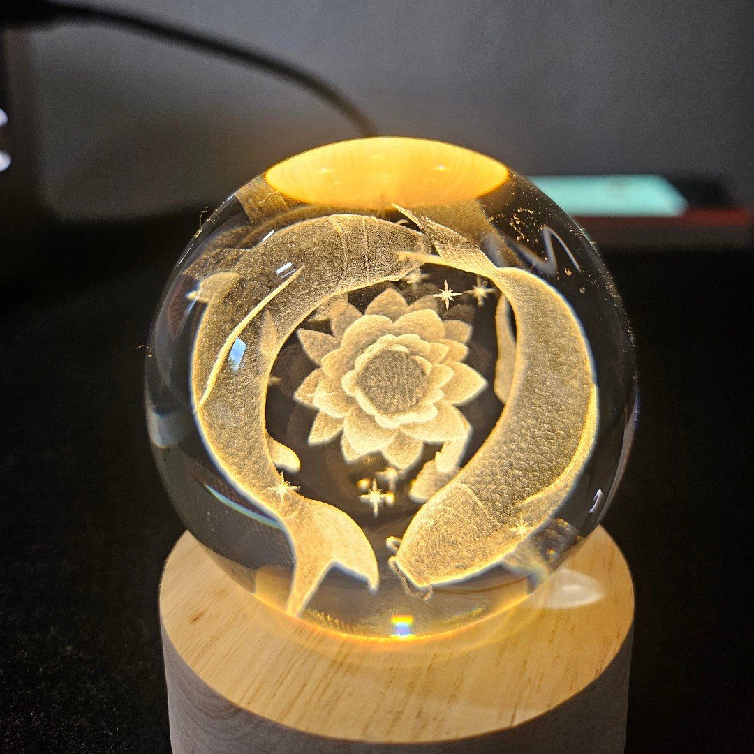 Bringing art to life inside crystal! There&rsquo;s something mesmerising about sub-surface crystal etching&mdash;the way thousands of micro-points suspend a 3D design inside a solid glass sphere, catching the warm light from the wooden LED base.

Swi