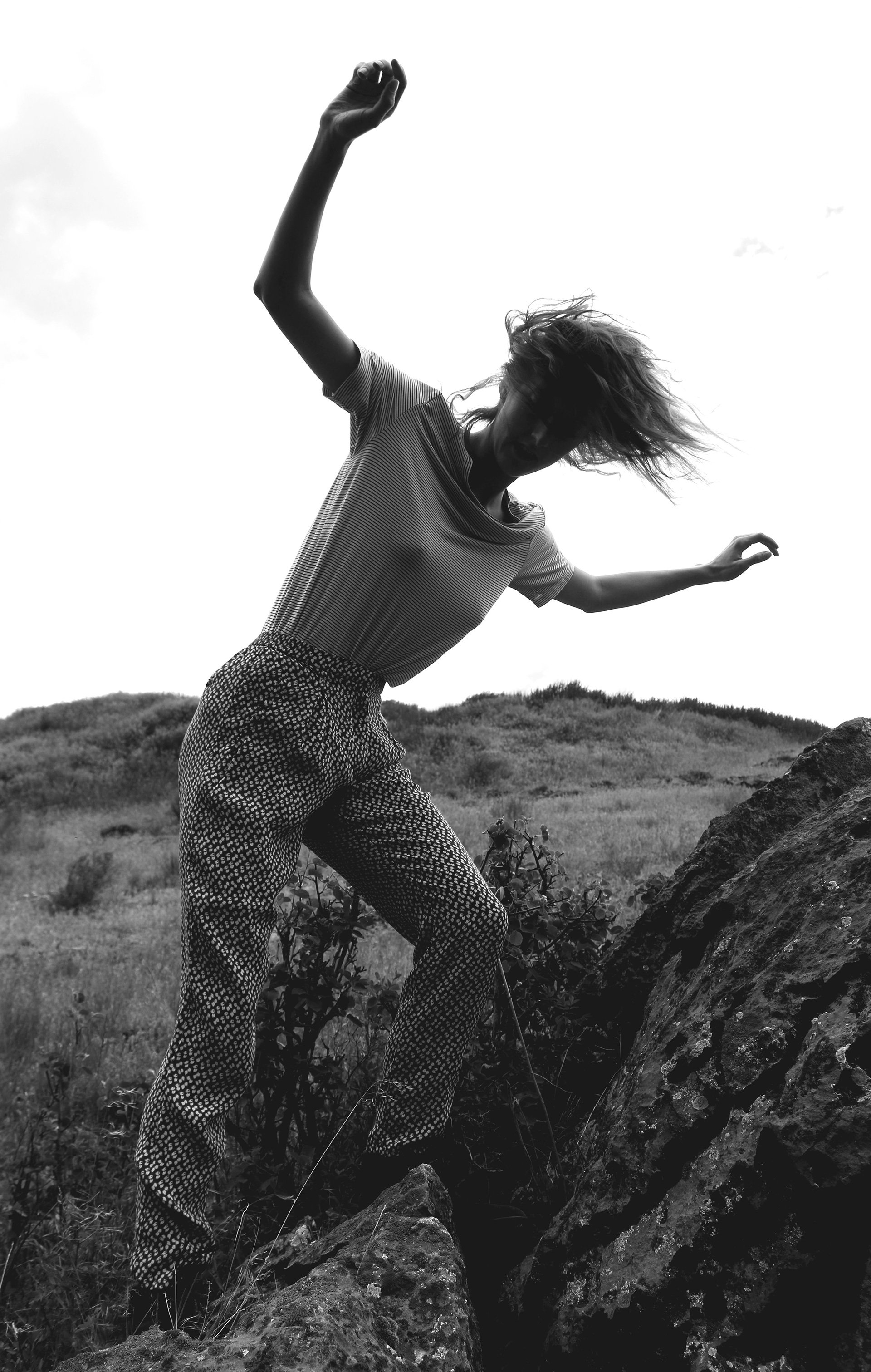 Michaela Ellingson dancing outdoors in a natural landscape.
