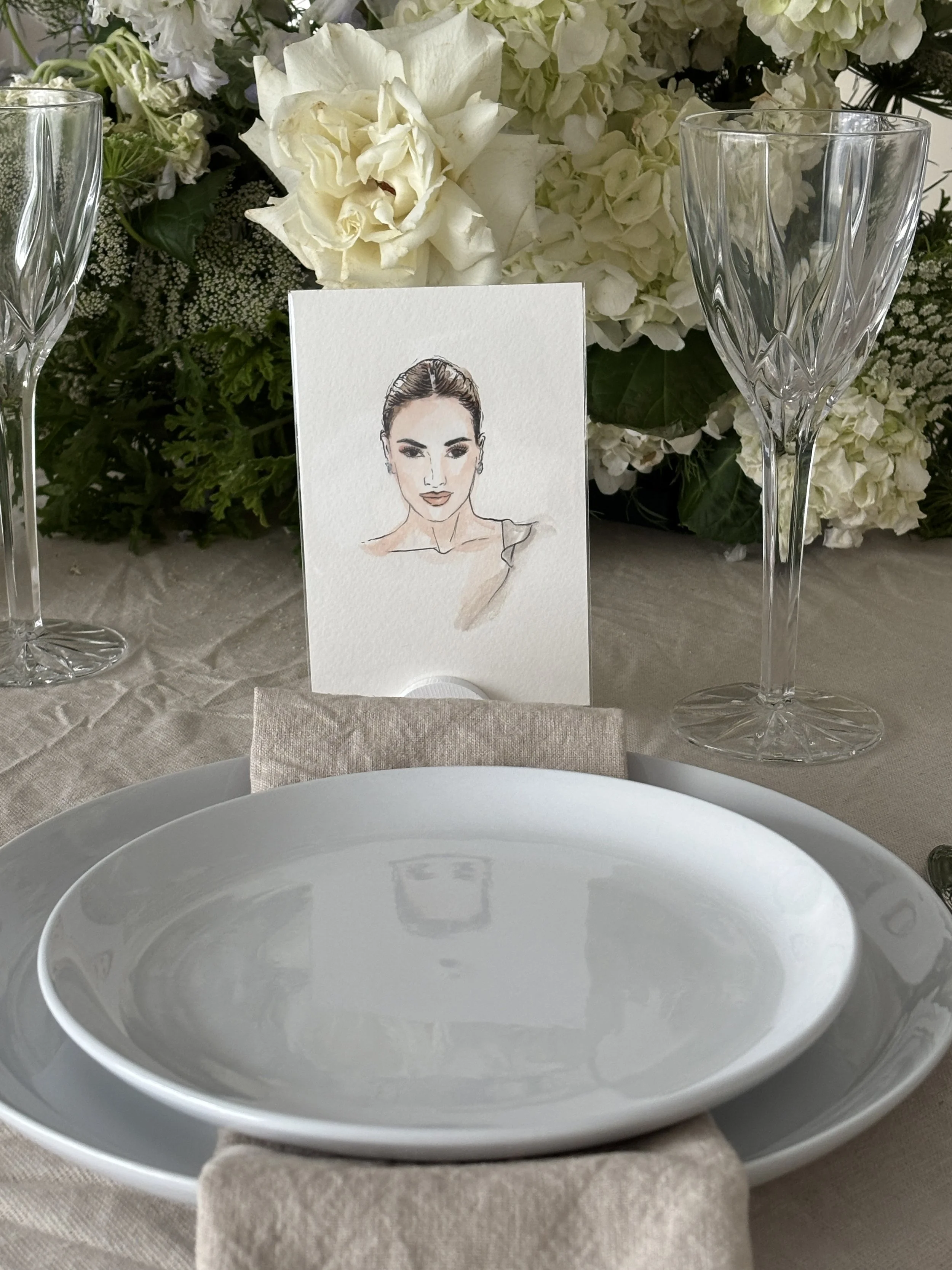 Hand-painted watercolour wedding guest portrait postcard at a styled place setting