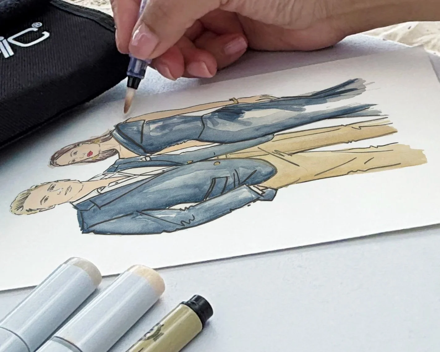 Crystal drawing a colour full-outfit wedding guest portrait during a live illustration experience.