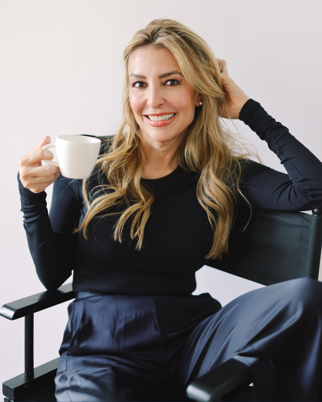 Raquel Kaufler, founder of MŪZ wellness tea brand, seated portrait holding a cup of tea.