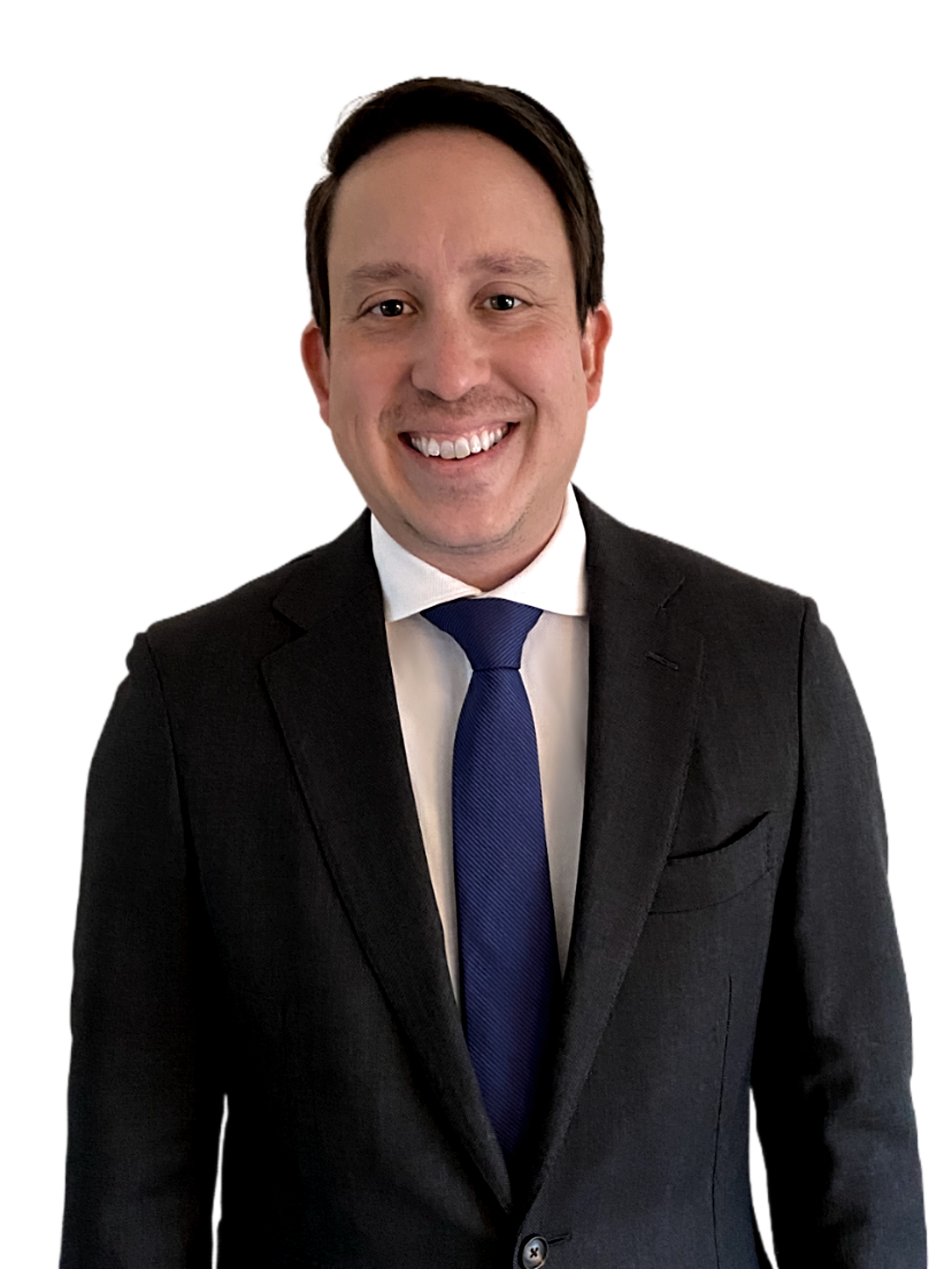 A smiling man in a black suit, white shirt, and blue tie, standing against a plain background.