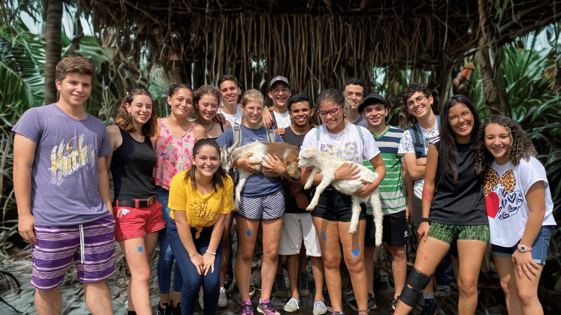 group photo of U.S and Costa Rica students sharing a fun photo with baby goats in the center