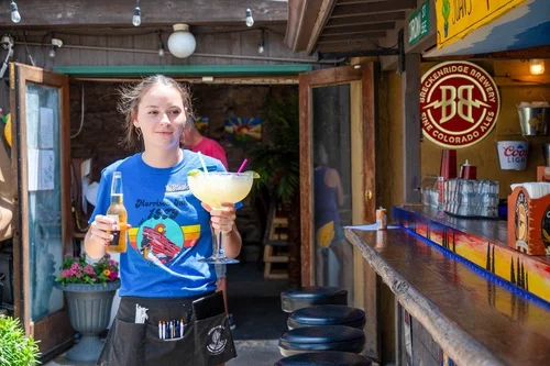 Server bringing a large margarita