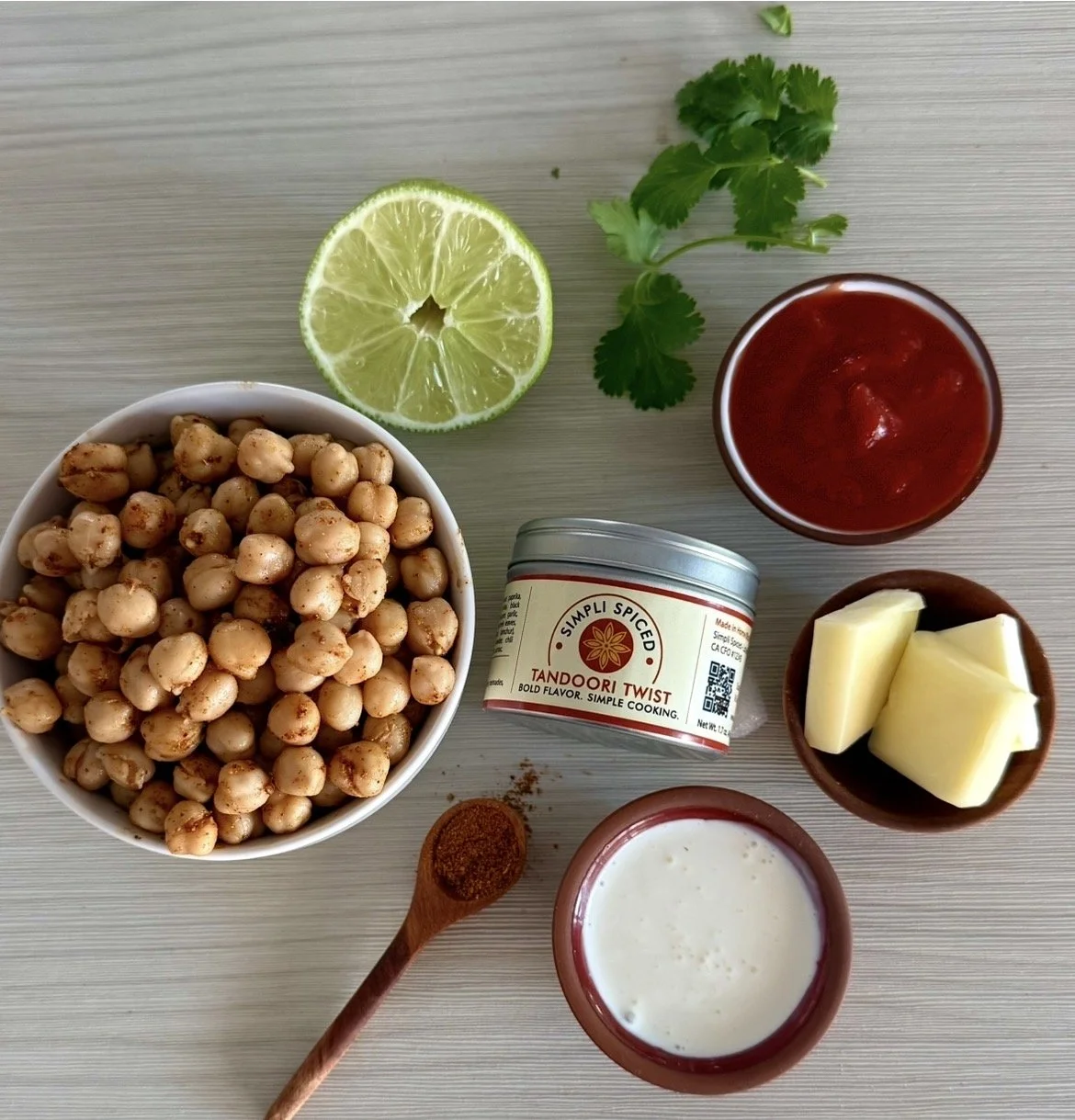 Ingredients for vegetarian butter chickpea curry including chickpeas, Simpli Spiced spices, and tomato sauce
