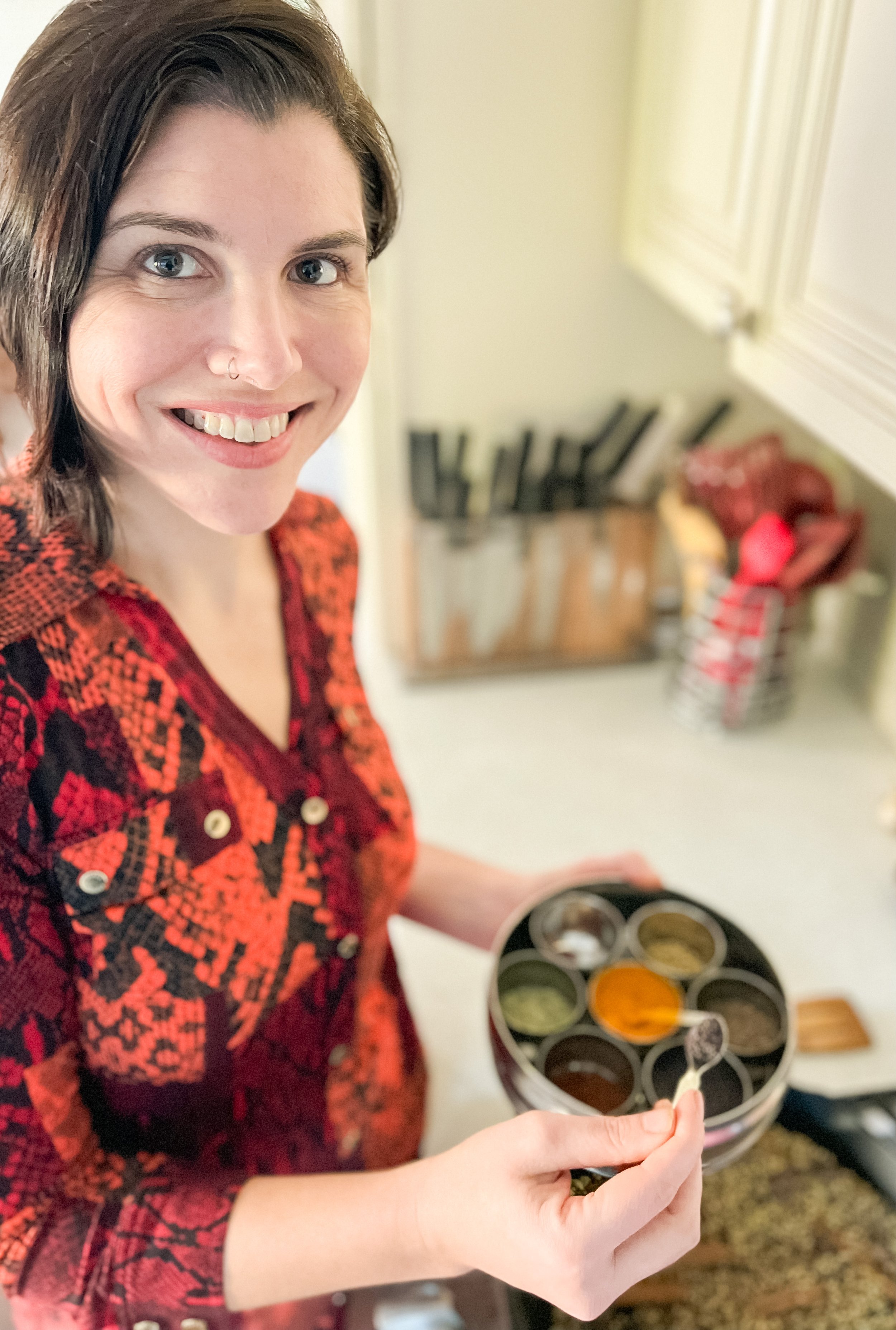 Founder of Simpli Spiced tasting spices while cooking