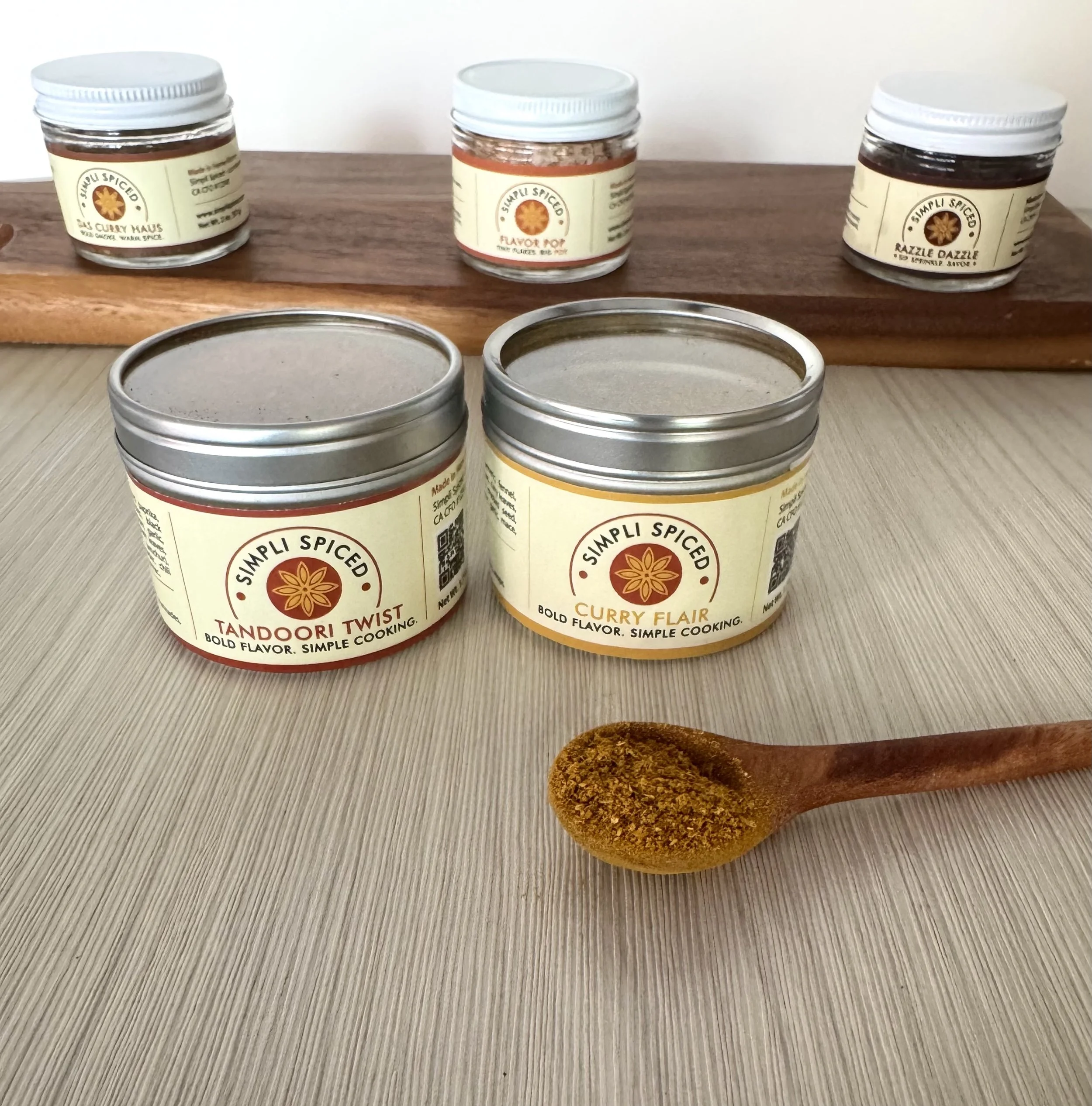 Simpli Spiced Indian spice blends and flavored sea salts displayed in jars including Tandoori Twist and Curry Flair