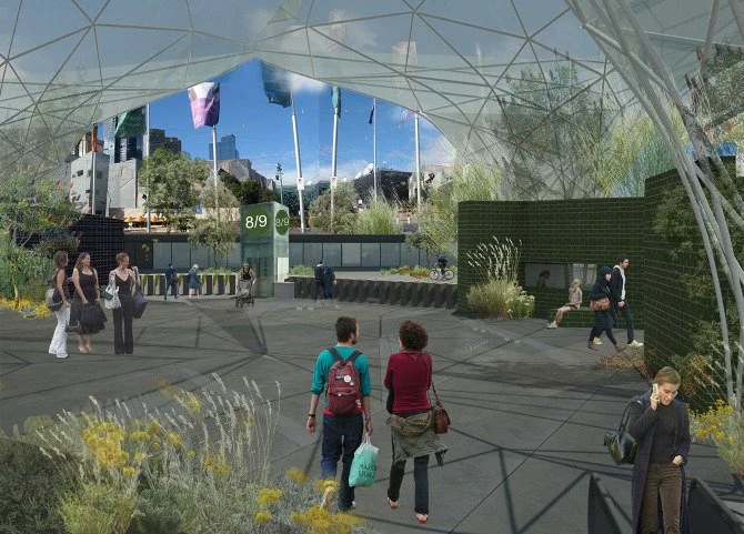 People walking and waiting in an outdoor urban space with greenery and modern architecture, and city skyscrapers in the background.