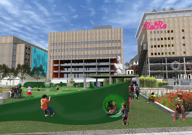 Children playing on a modern outdoor playground with a large curved green slide and a tunnel, in front of urban buildings including a 'RaRa' sign and a building with a 'Starbucks' logo.
