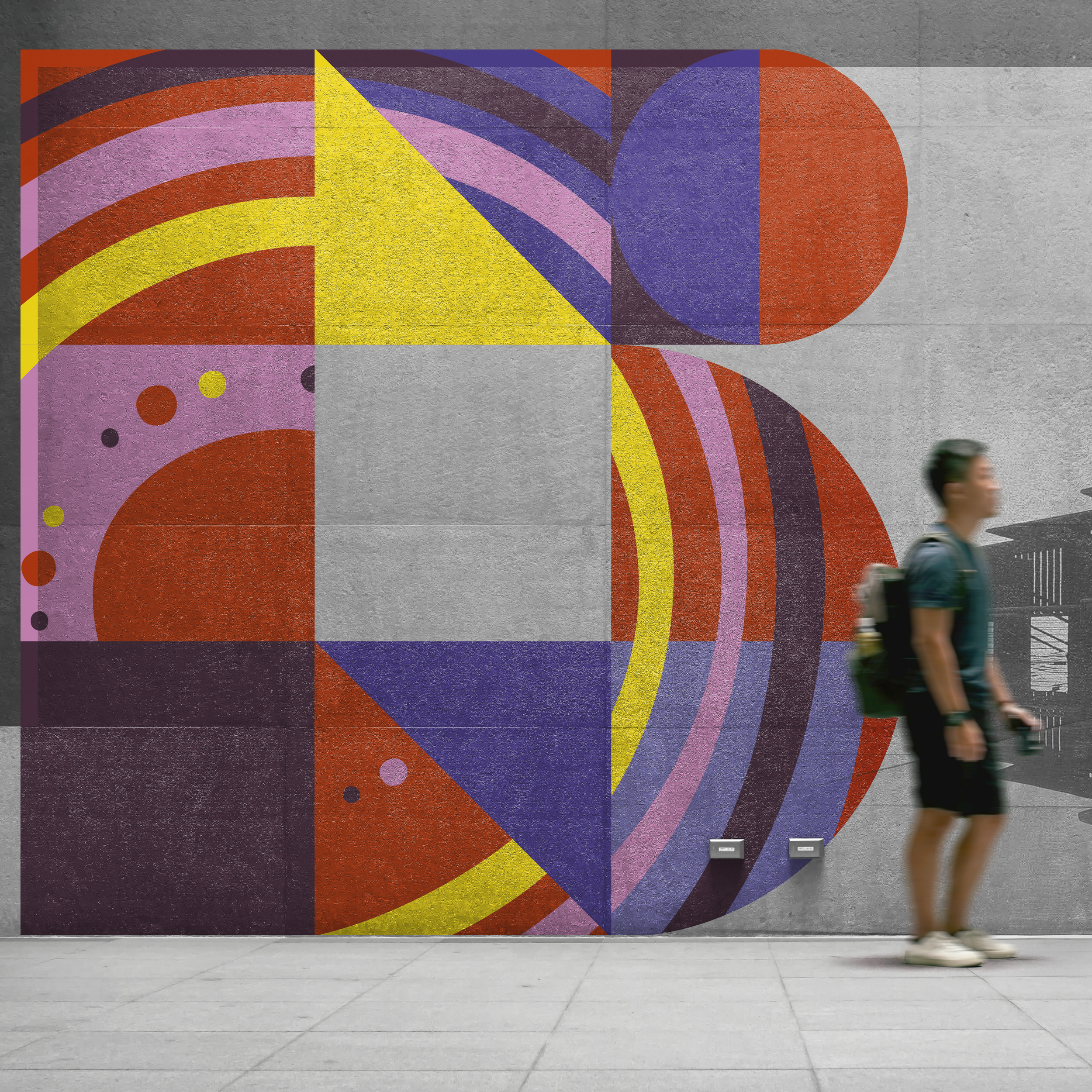 A colorful abstract mural featuring geometric shapes and patterns, with a person walking past on the sidewalk.