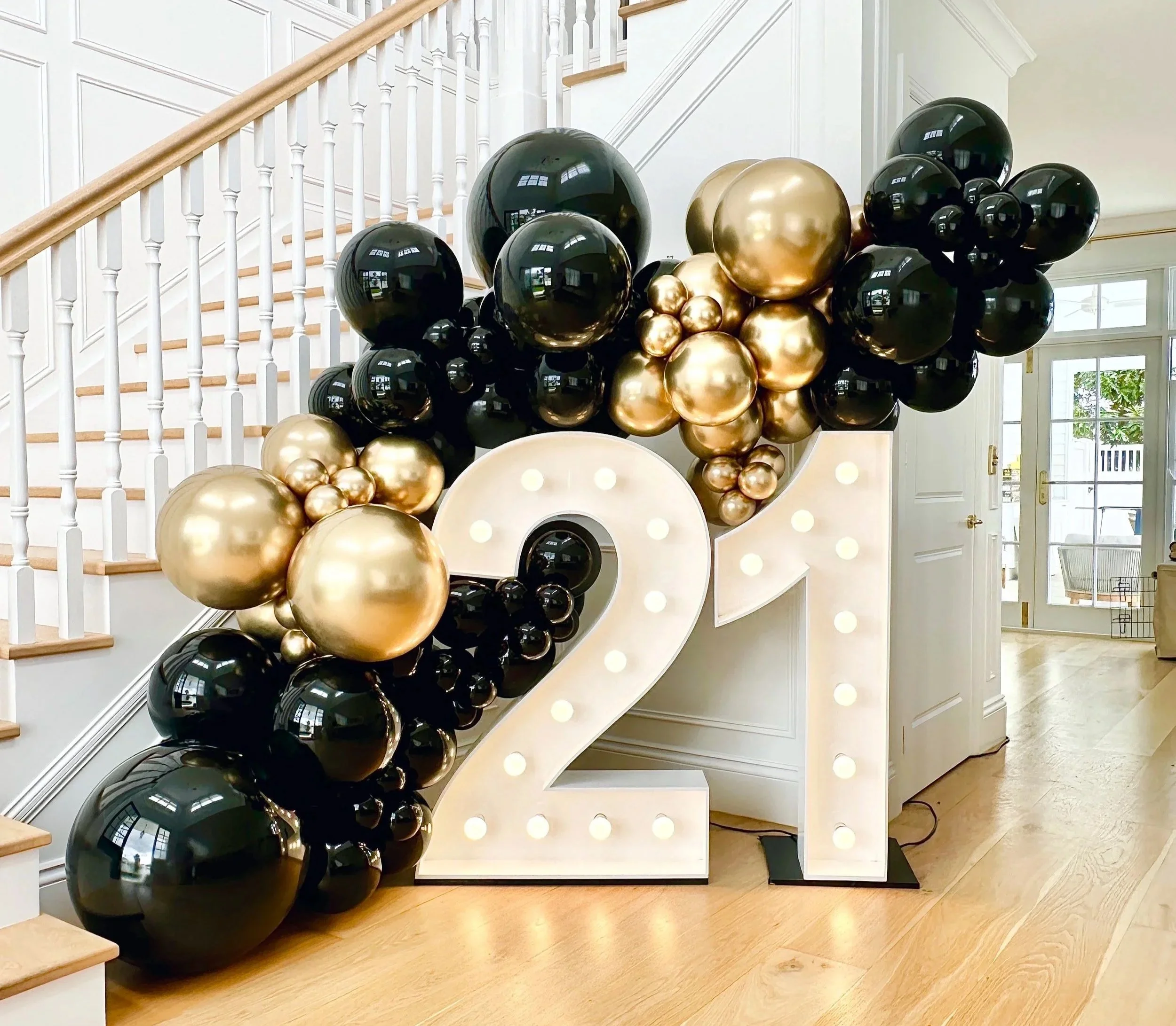 Balloon wall surrounding large illuminated white number 21 for a Twenty First birthday party