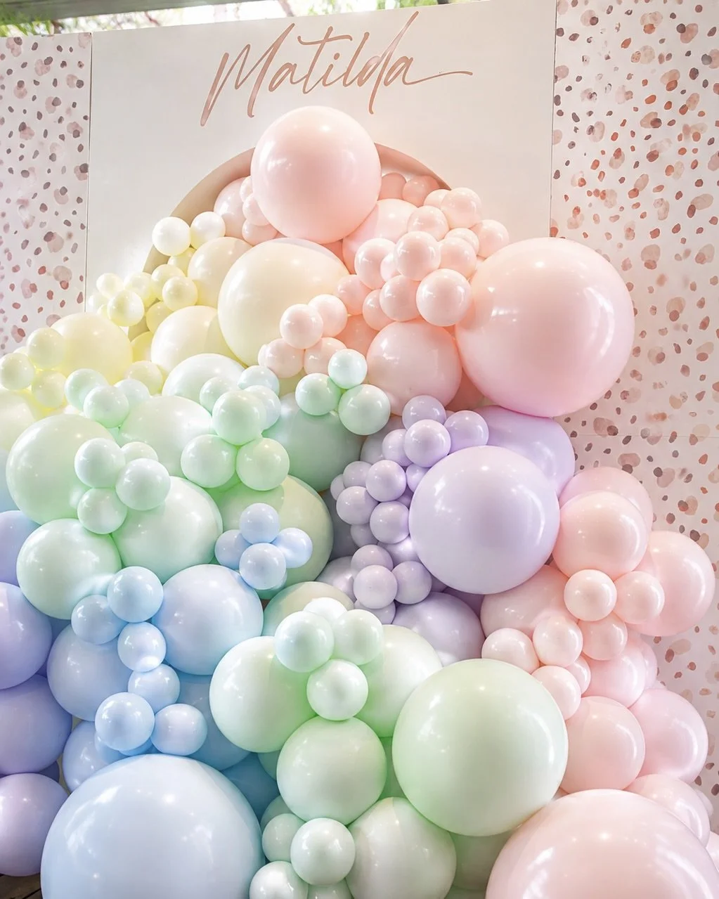 Pastel balloon wall in pink, green, purple, and yellow by Print Candy