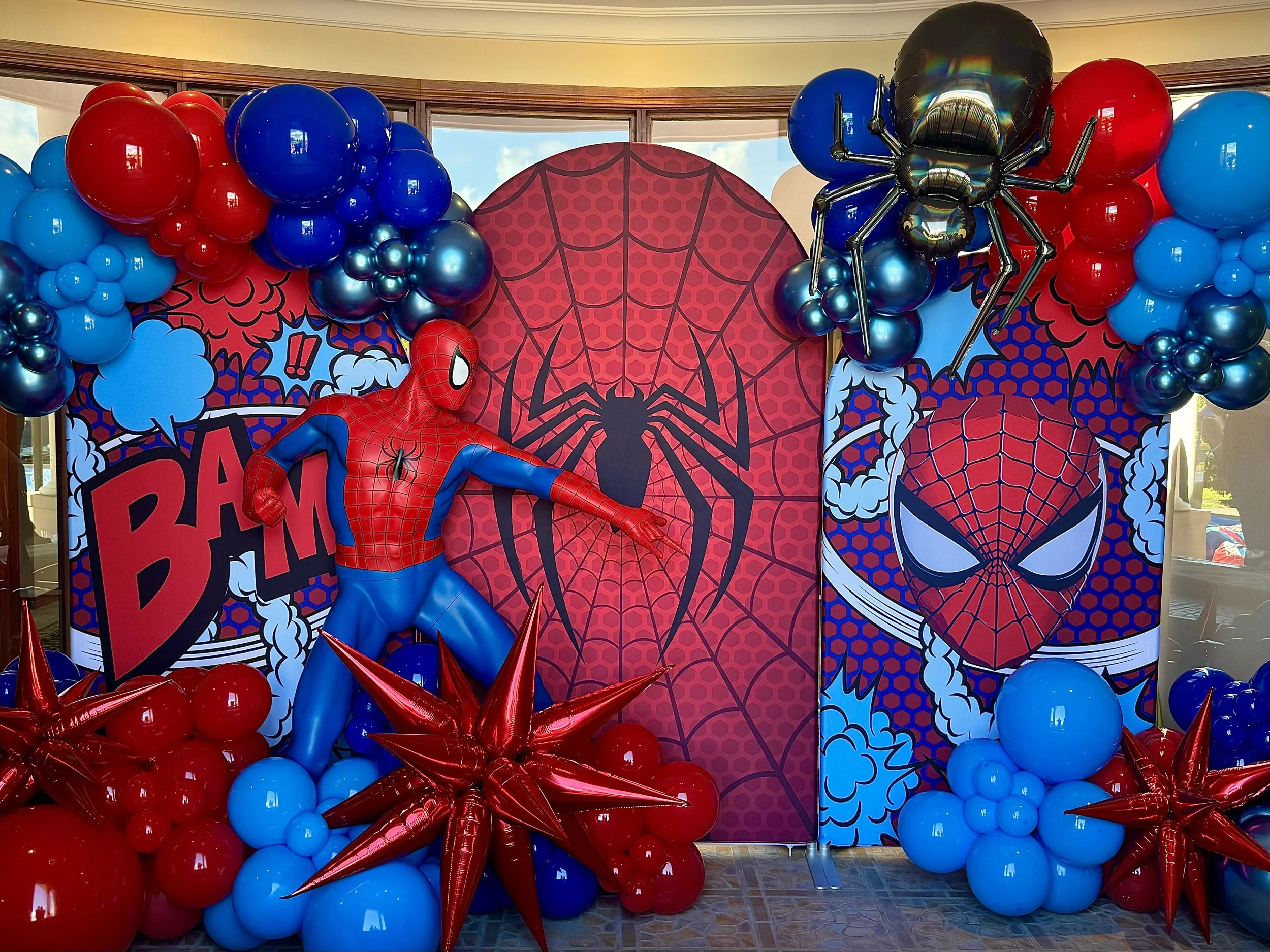 Spider-Man themed party arches with Spiderman themed balloons and props