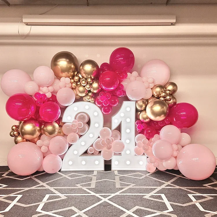 Balloon wall surrounding large illuminated white number 21 for a Twenty First birthday party
