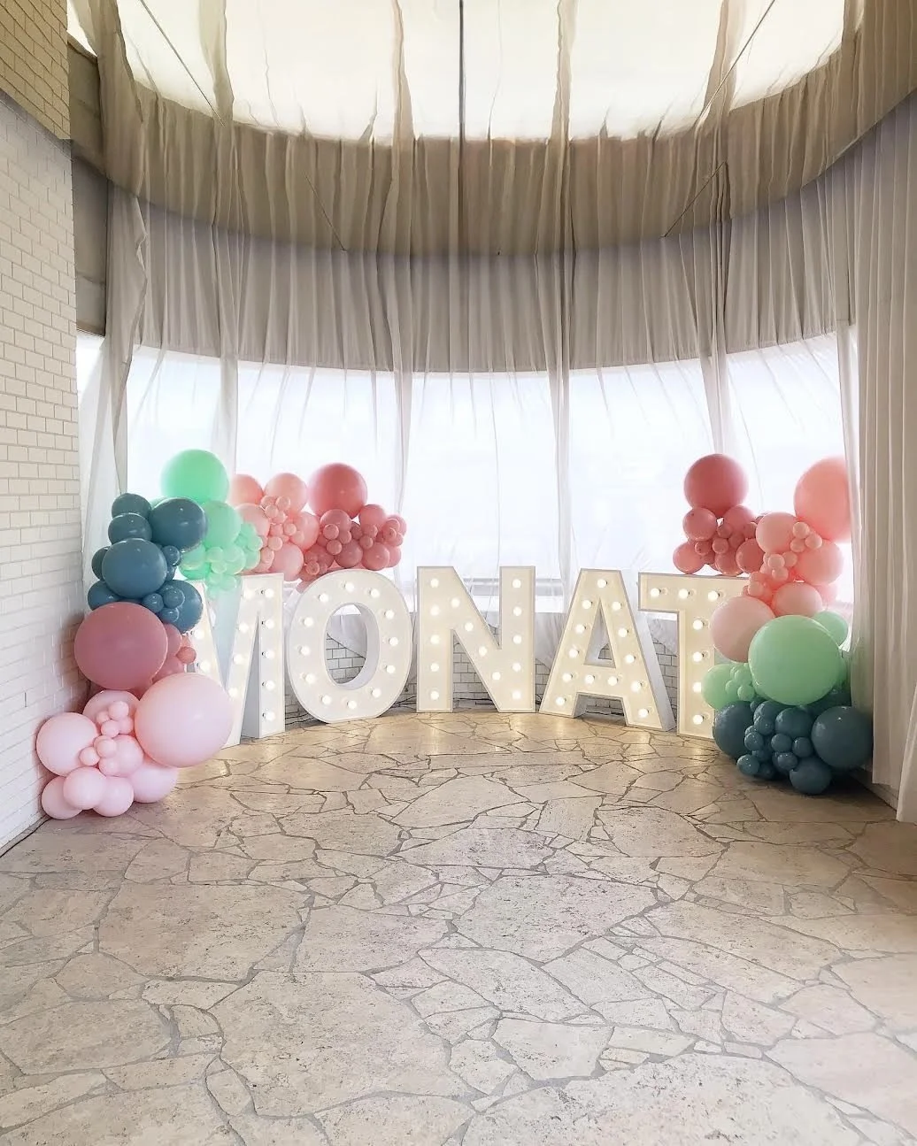 Event backdrop for Monat  featuring balloons and light up letters
