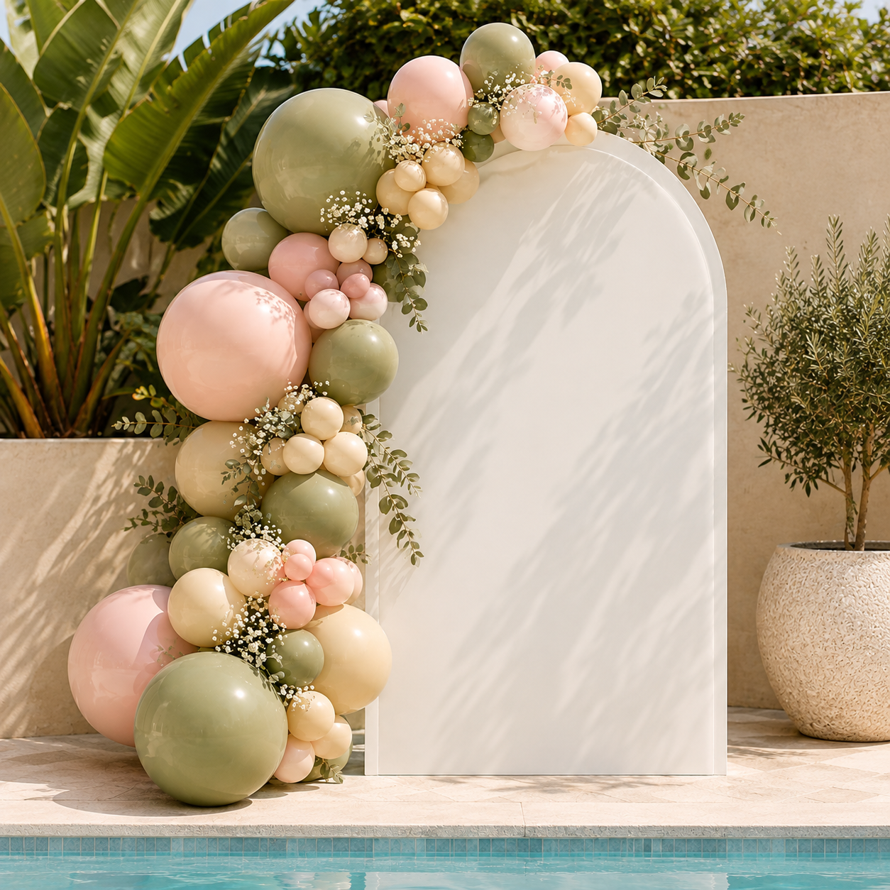 White balloon arch set up by a beautiful pool