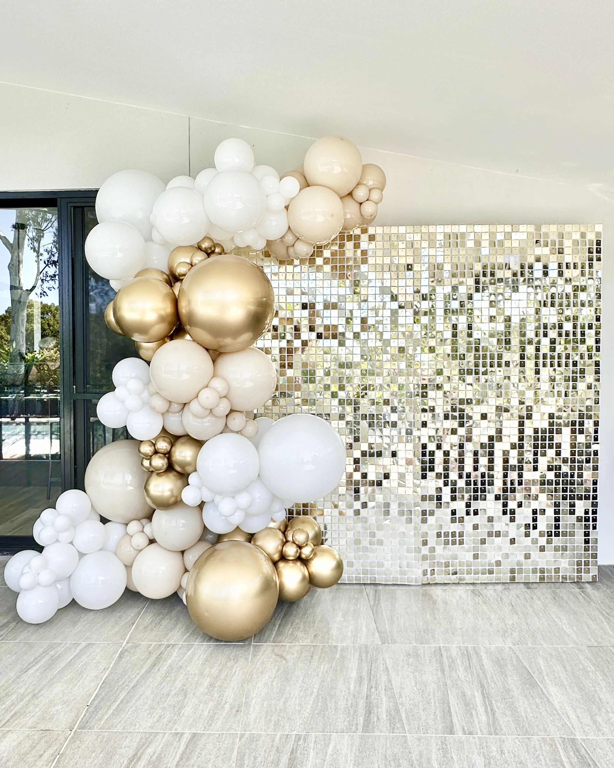 Gold graduation backdrop styled for a Year 12 pre formal party featuring a gold shimmer wall, personalised disc sign and balloons