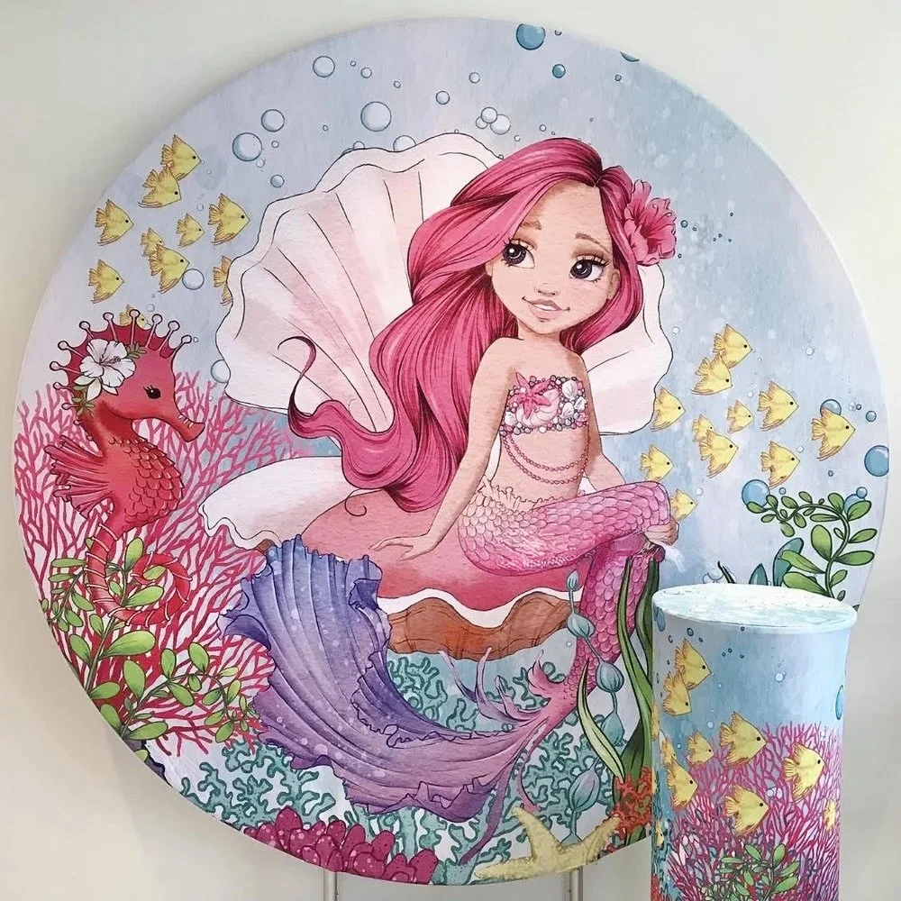 Round mermaid themed backdrop. Mermaid with long pink hair, sitting on a shell surrounded by sea creatures like seahorses, fish, and coral
