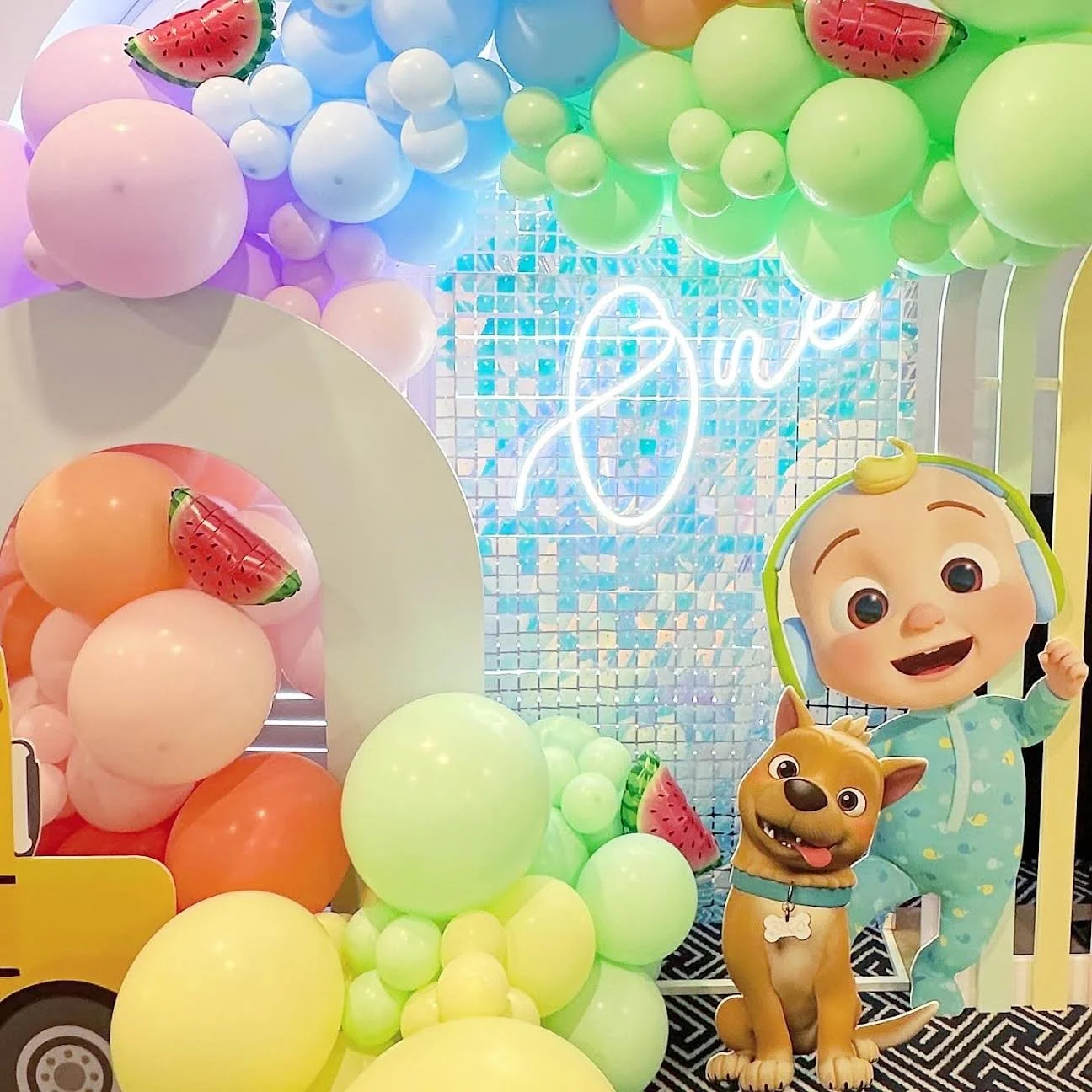 Coco melon first birthday theme with themed props and a One neon sign