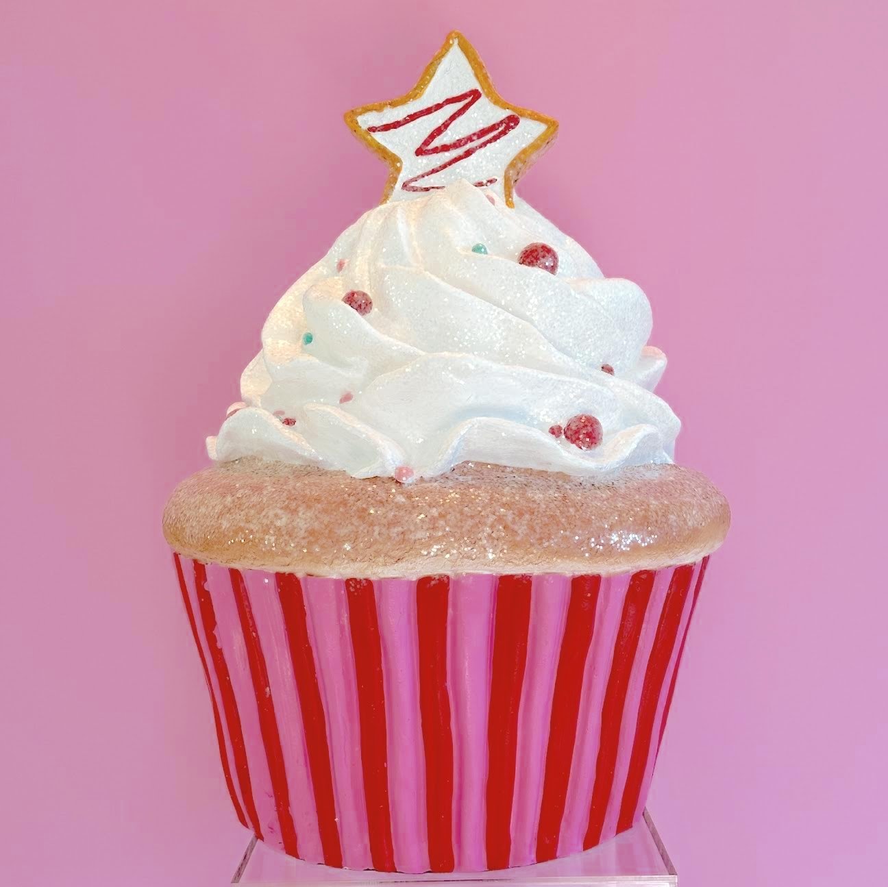 Life size pink Christmas cupcake prop with a star on top and glitter