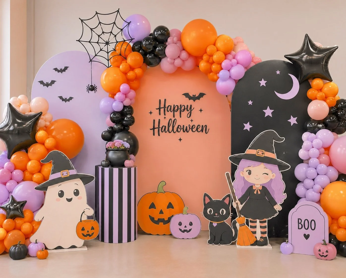 Halloween-themed party decoration with colorful balloons, paper cutouts of witches, a black cat, pumpkins, bats, a broomstick, a witch character with purple hair and a hat, a ghost character with a witch's hat, a spider web, and a sign that says "Happy Halloween".