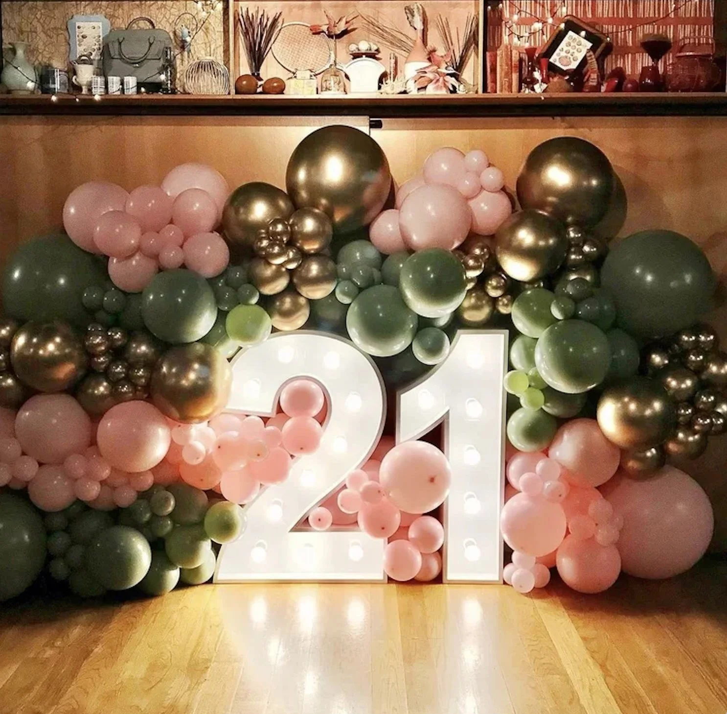 Decorative balloon arrangement surrounding illuminated white number 21