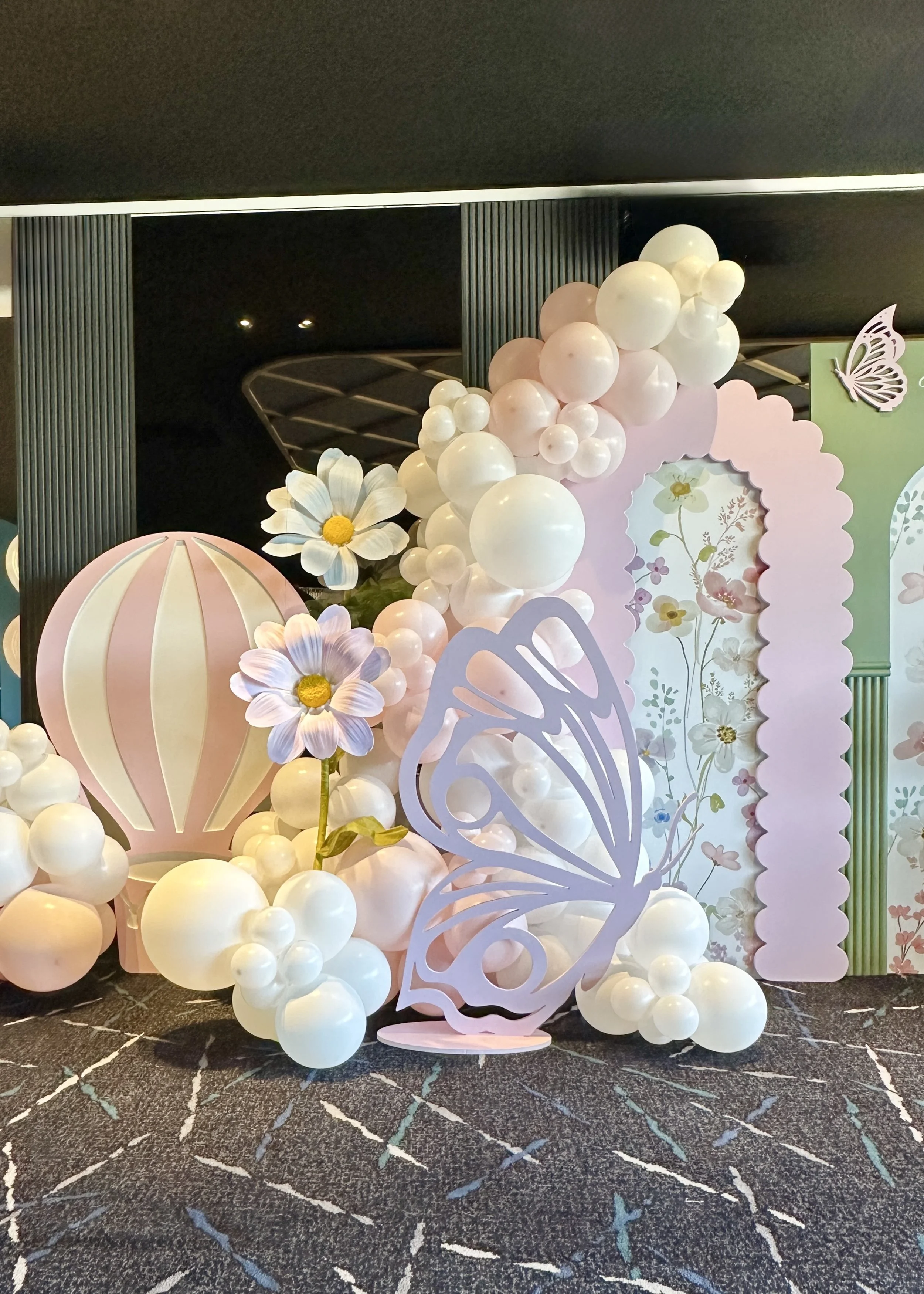Baby in Bloom baby shower celebration. Featuring pastel pink, white, and green balloons, flower hire, butterfly props, hot air balloon props and floral backdrops