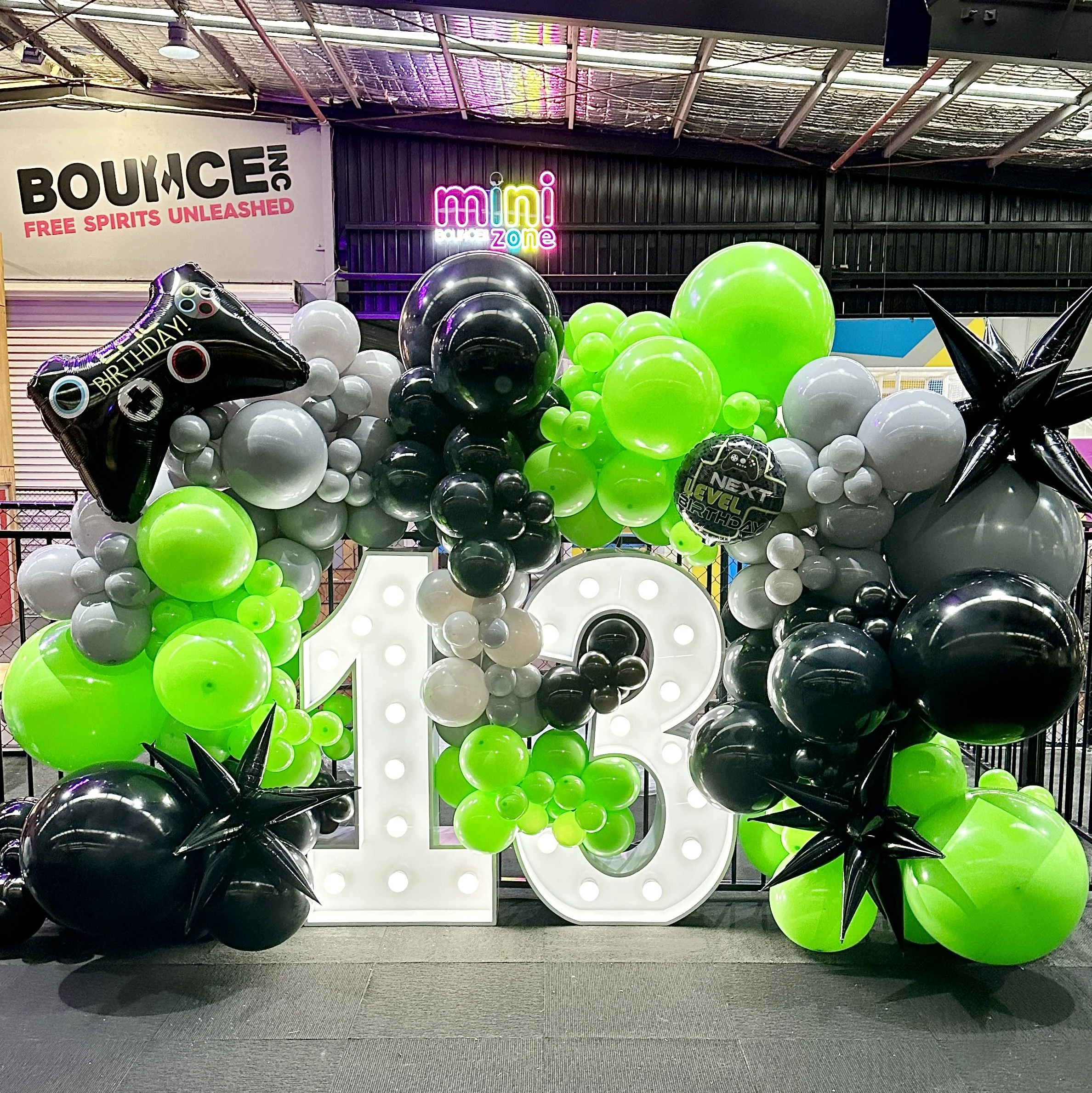 Gamer themed 13th Birthday. Balloon wall surrounding large illuminated white number 13